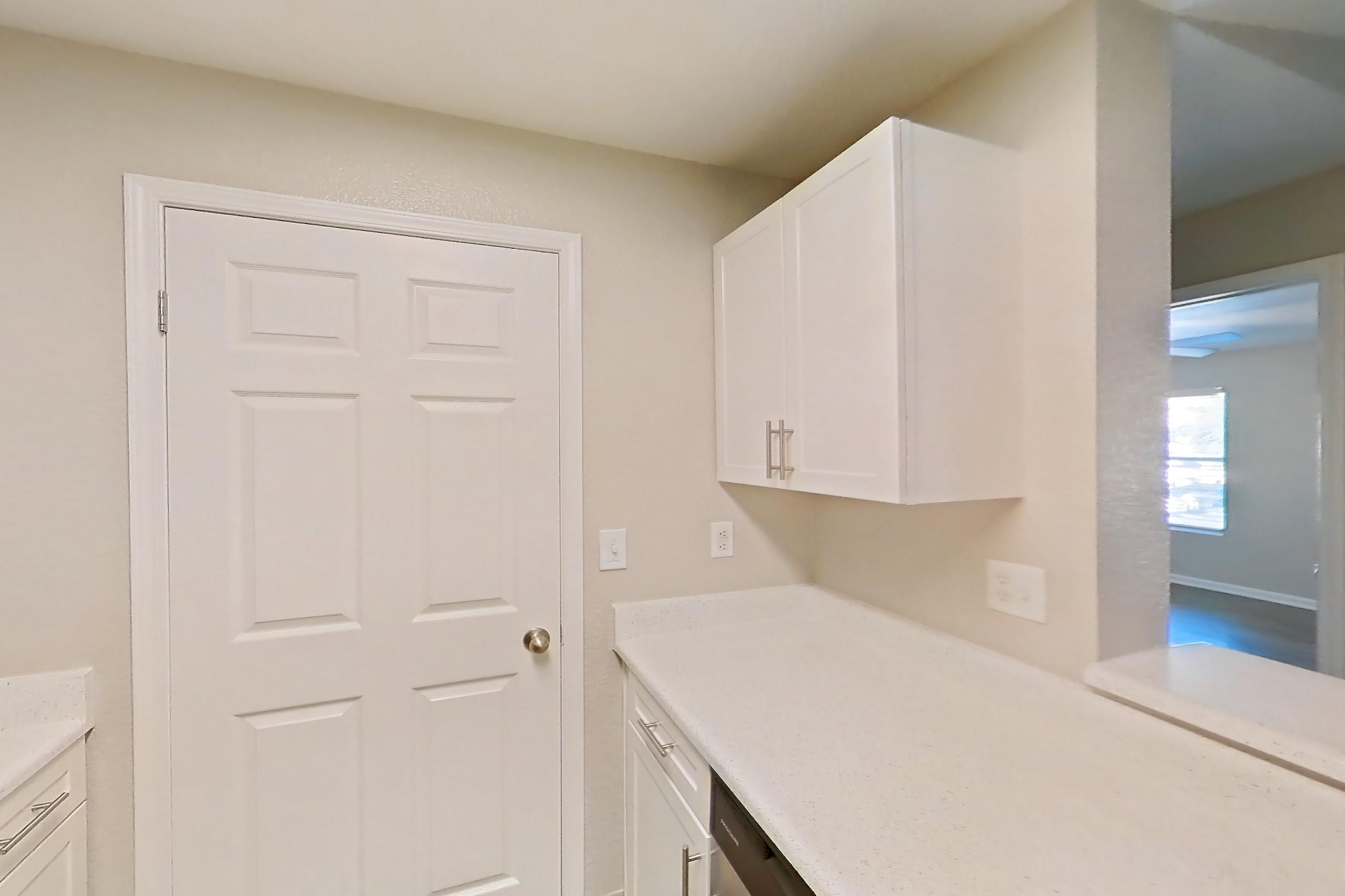 Kitchen with dishwasher, electric range, light countertops, light stone countertops, light wood-finish flooring, microwave, oven/range, refrigerator, and stainless steel appliances, Apartment 30-2084 at Xander 3900