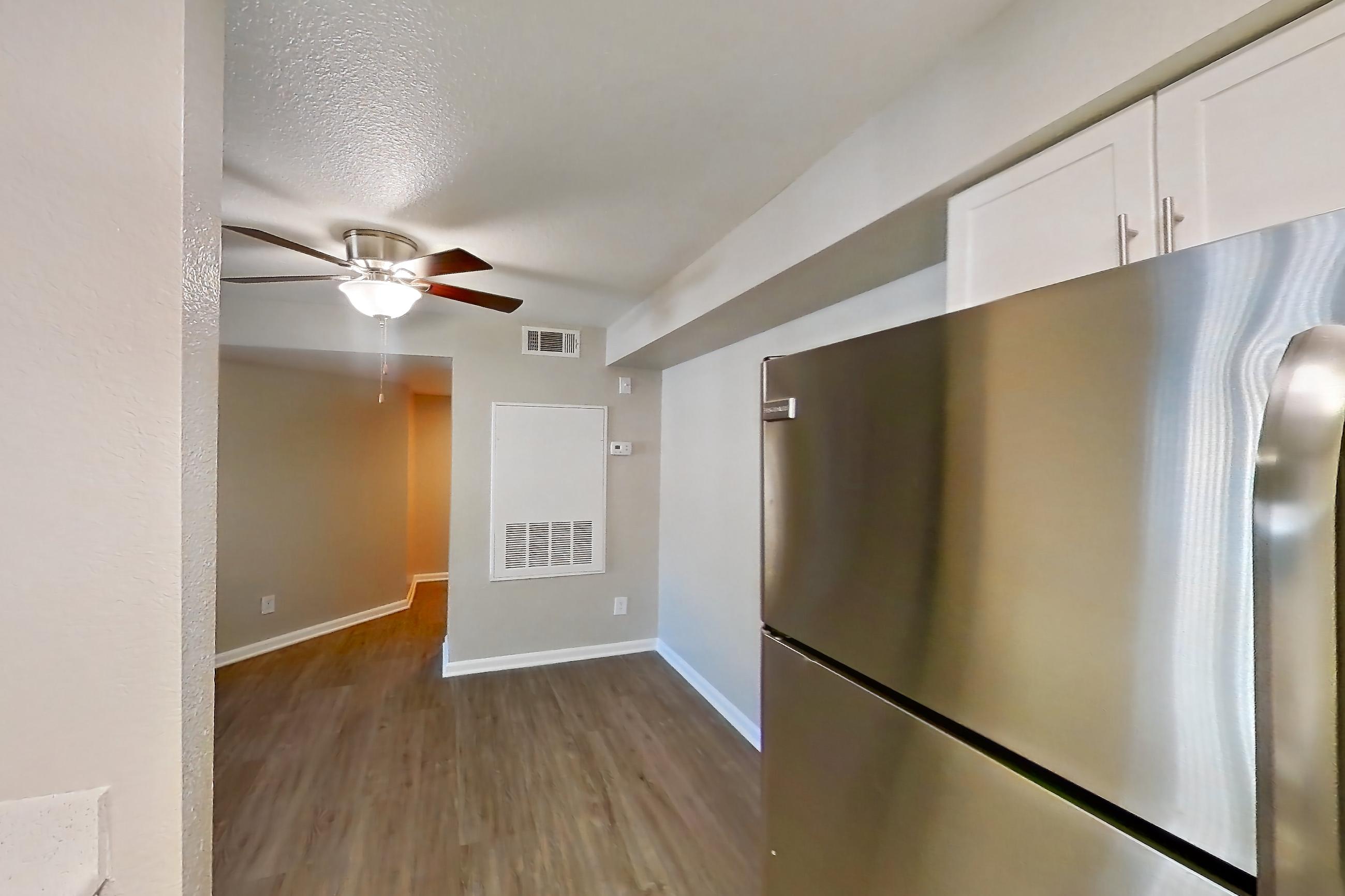 Kitchen with dishwasher, electric range, light countertops, light stone countertops, light wood-finish flooring, microwave, oven/range, refrigerator, and stainless steel appliances, Apartment 30-2084 at Xander 3900
