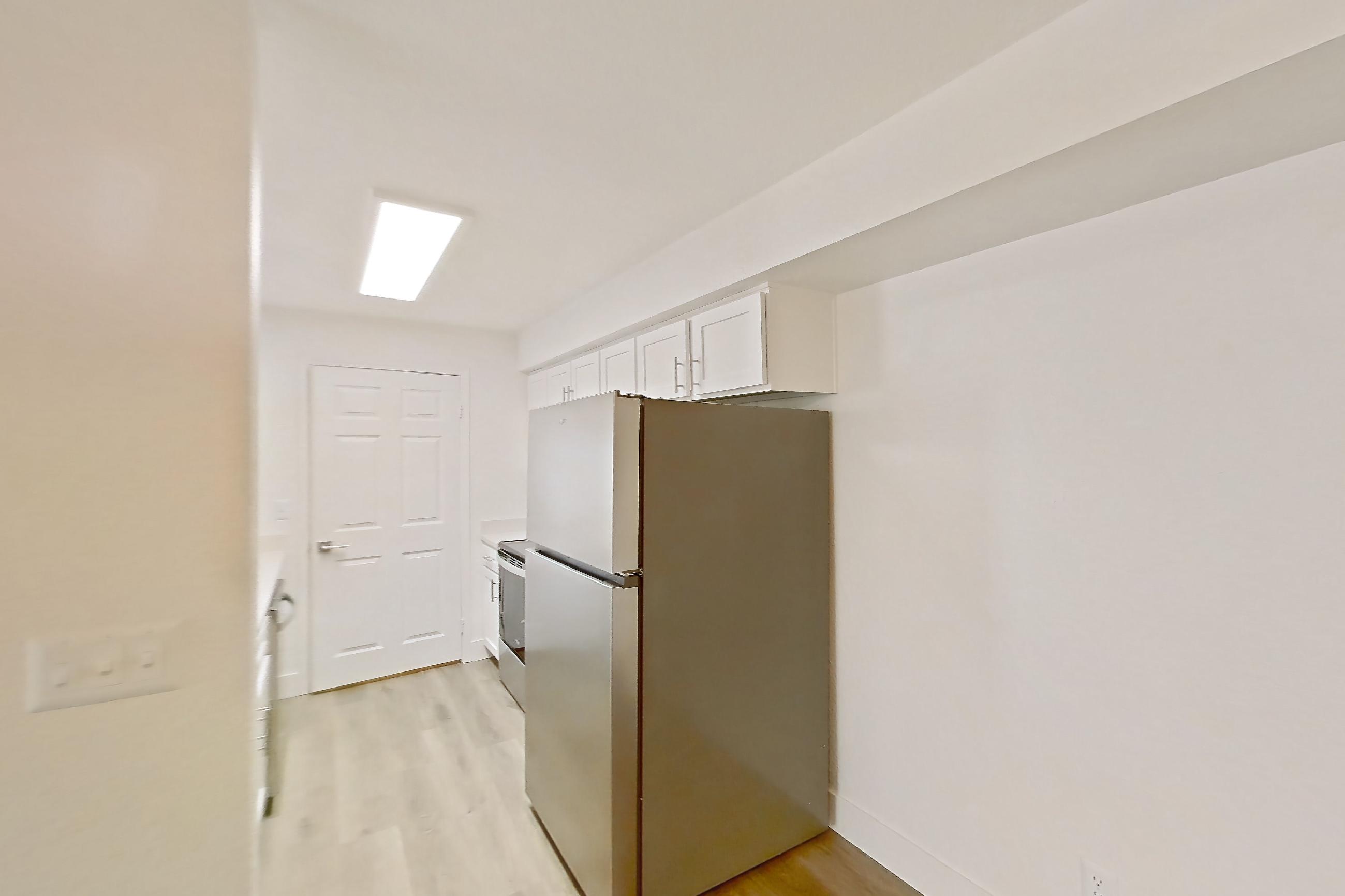 Dining room with light countertops, light wood-finish flooring, oven/range, refrigerator, and stainless steel appliances, Apartment 30-2083 at Xander 3900