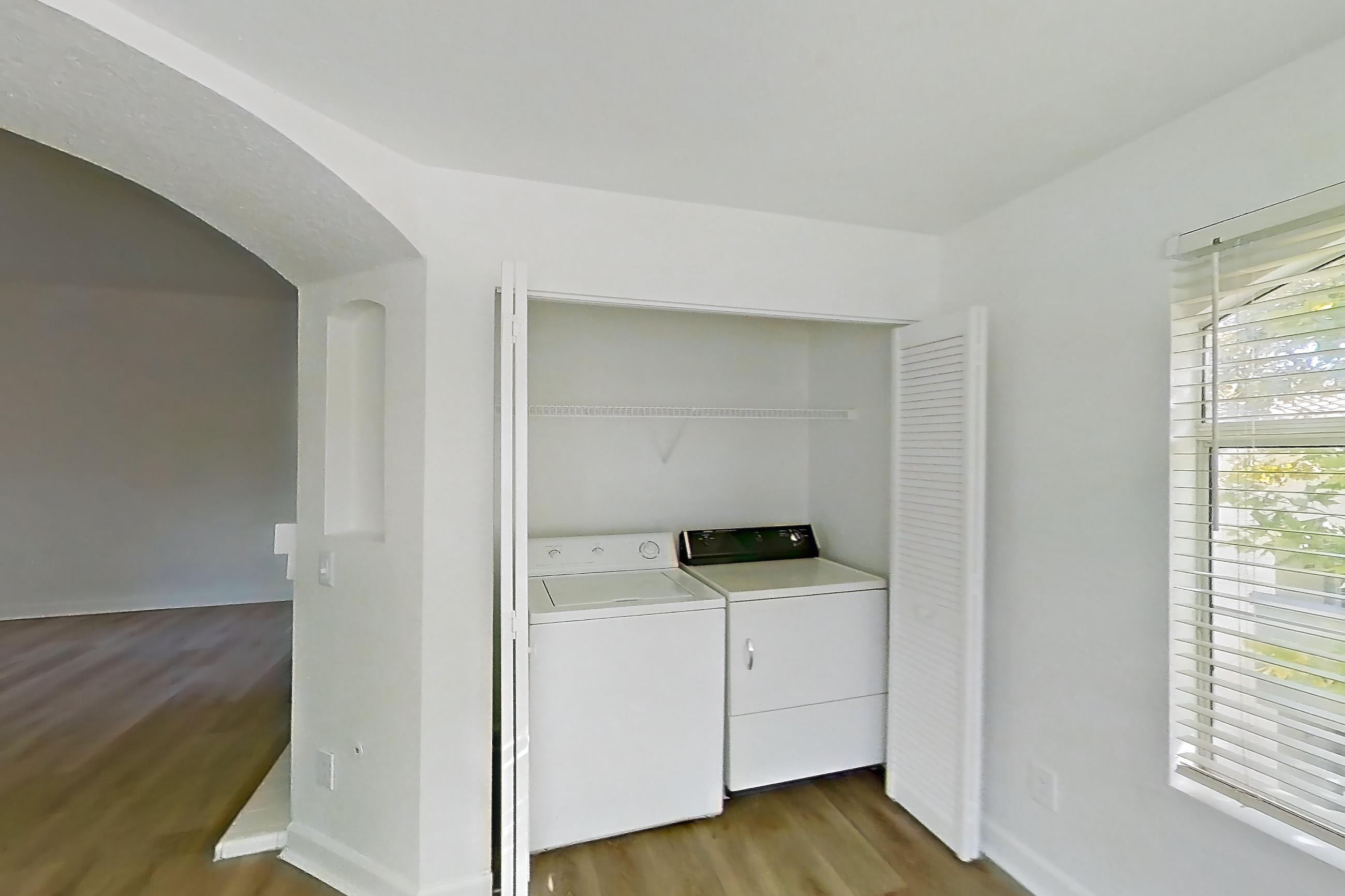 Dining room with dark wood-finish flooring, dishwasher, in-unit laundry, light countertops, light wood-finish flooring, and stainless steel appliances, Apartment 2110 at Vintage Pointe