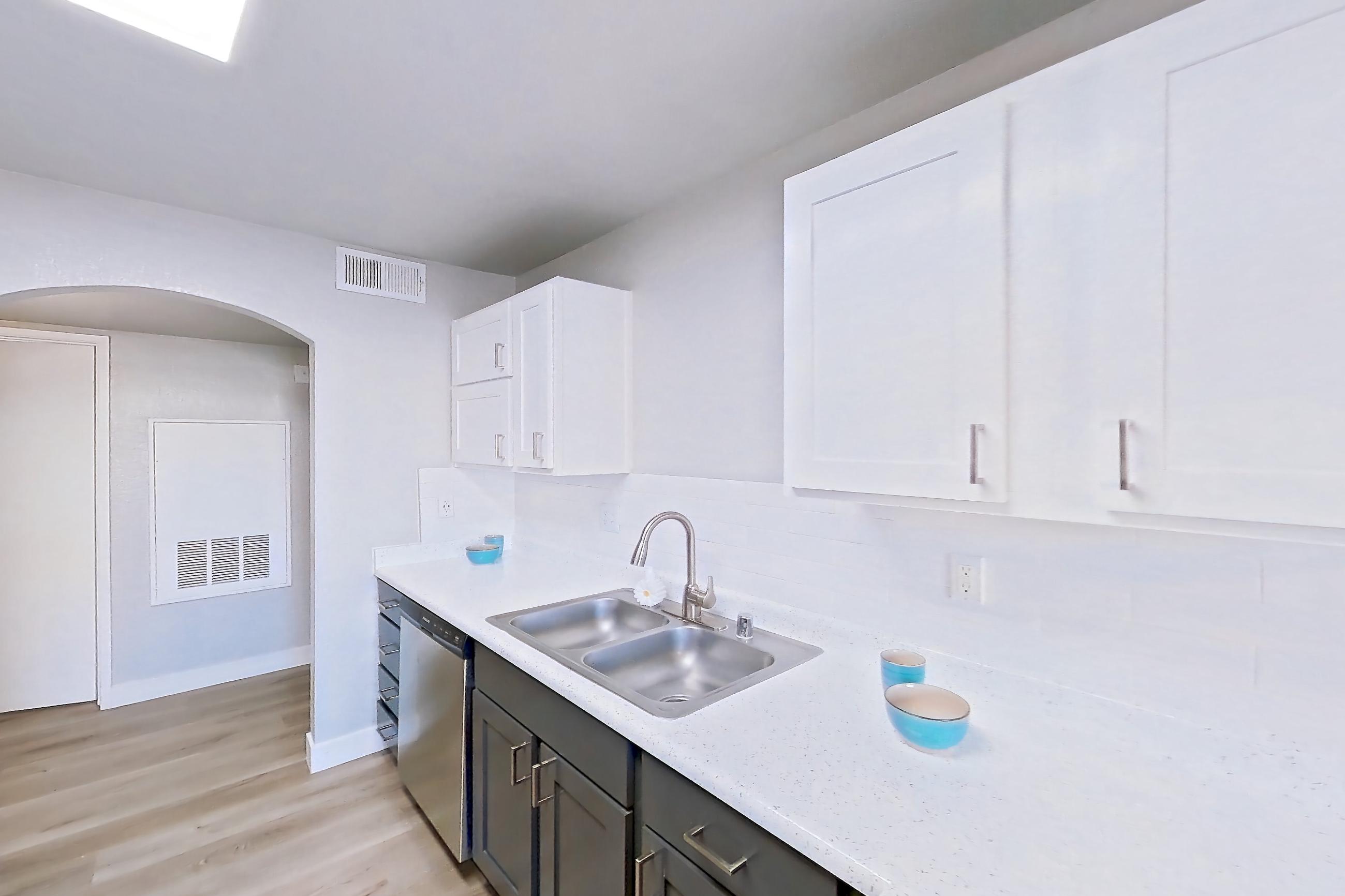 Kitchen with dishwasher, gas range, light stone countertops, light wood-finish flooring, microwave, oven/range, refrigerator, and stainless steel appliances, Apartment 1109 at Vintage Pointe