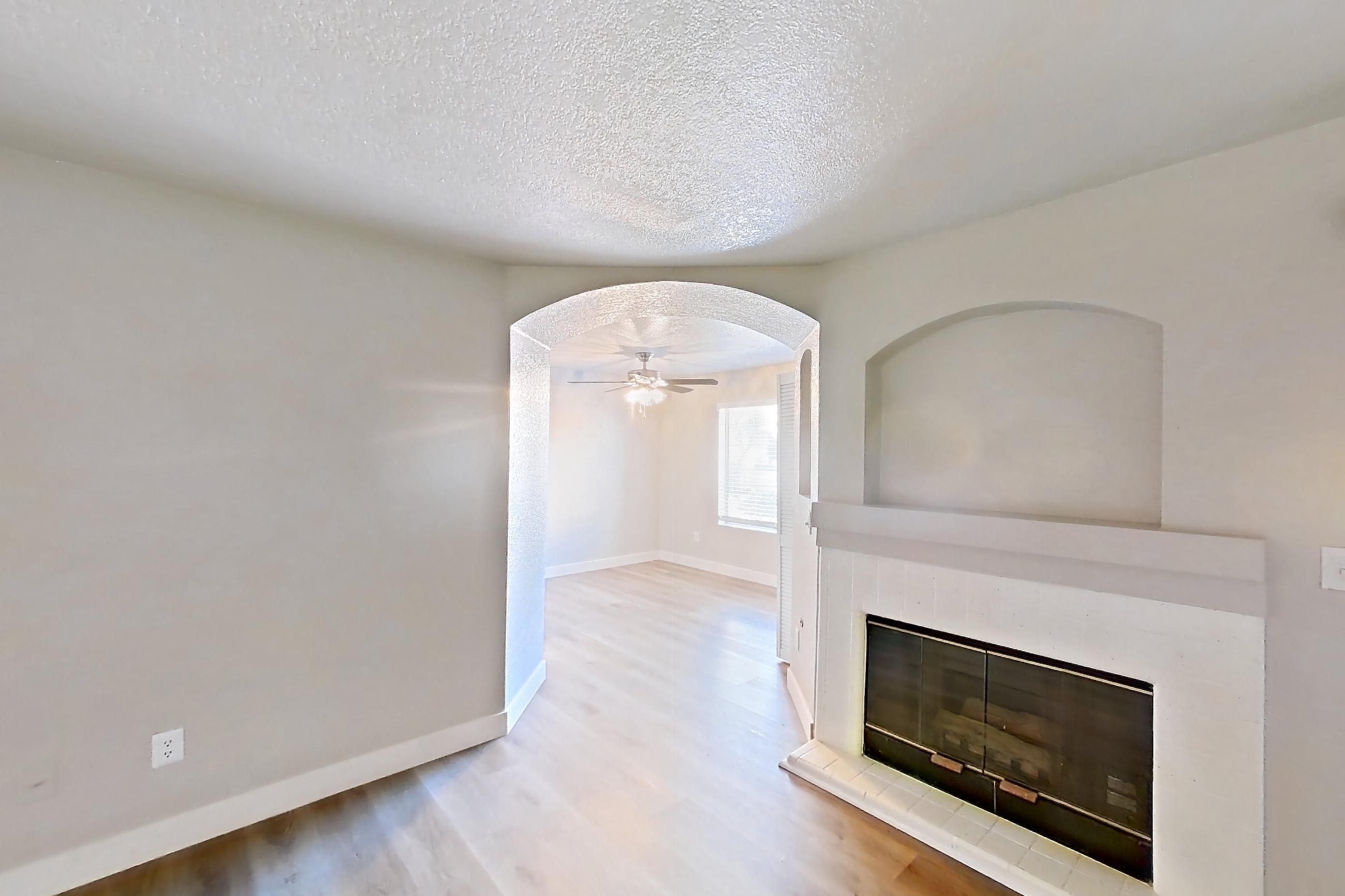 Living room with fireplace and light wood-finish flooring, Apartment 1109 at Vintage Pointe