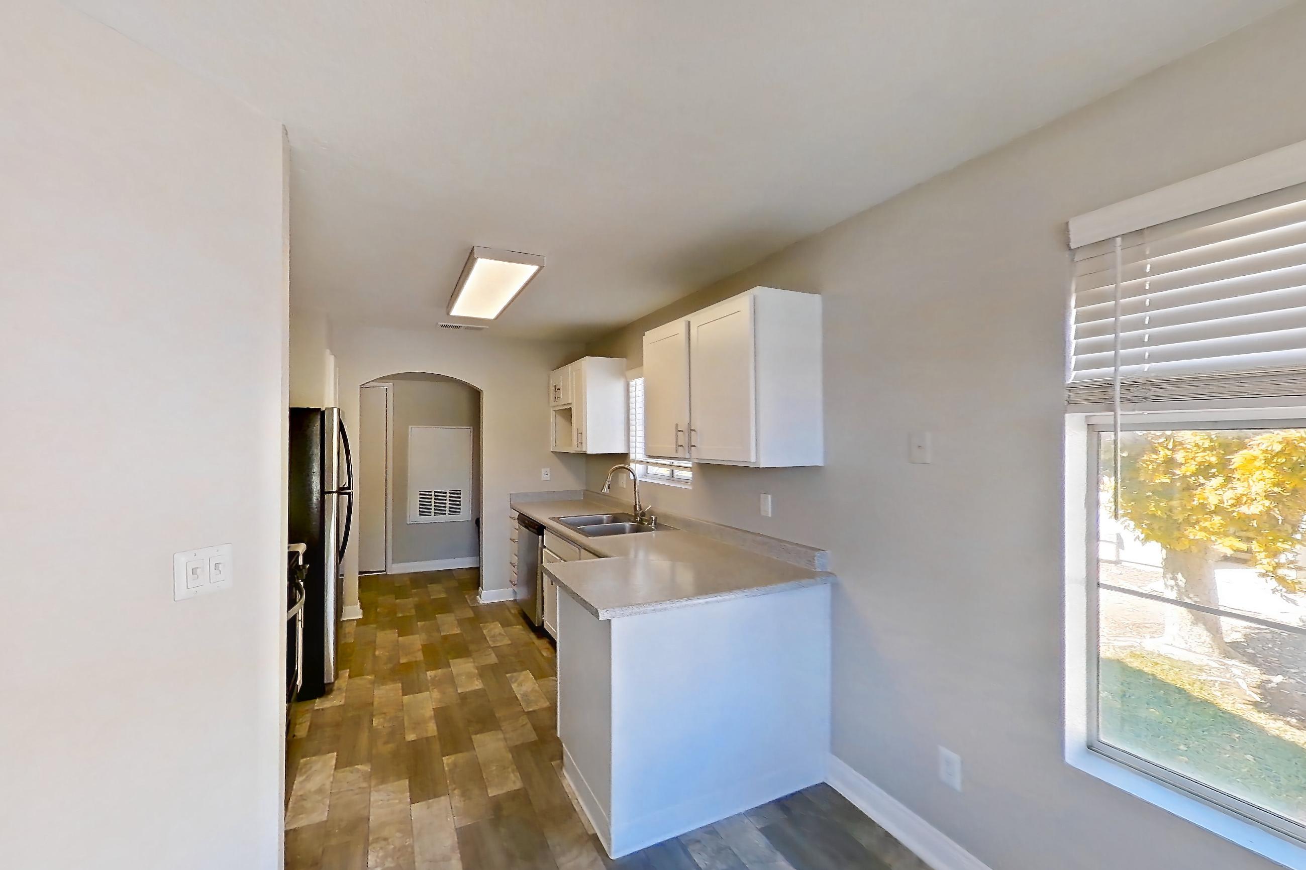 Dining room with dark wood-finish flooring, in-unit laundry, light countertops, and light wood-finish flooring, Apartment 2081 at Vintage Pointe