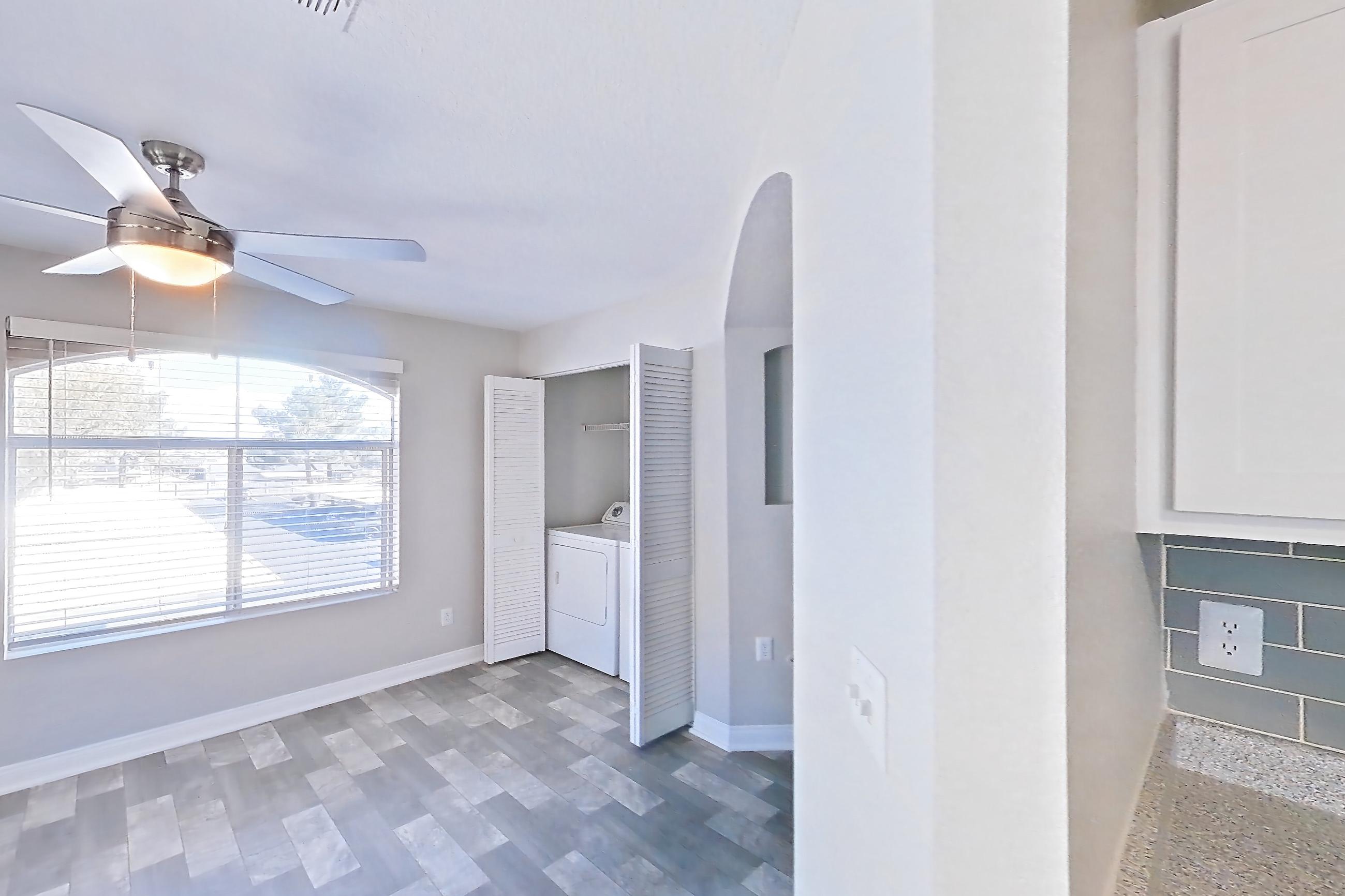 Kitchen with dishwasher, gas range, in-unit laundry, light countertops, light stone countertops, light wood-finish flooring, microwave, oven/range, refrigerator, and stainless steel appliances, Apartment 2081 at Vintage Pointe