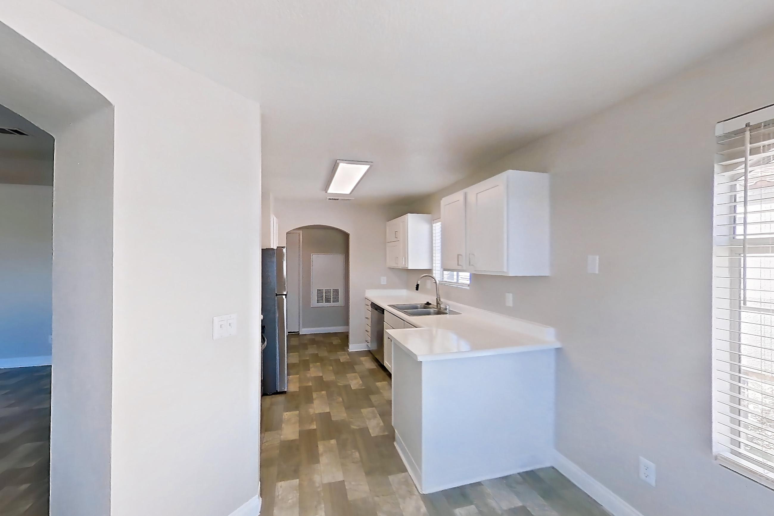 Dining room with dark wood-finish flooring, in-unit laundry, light countertops, and light wood-finish flooring, Apartment 2089 at Vintage Pointe