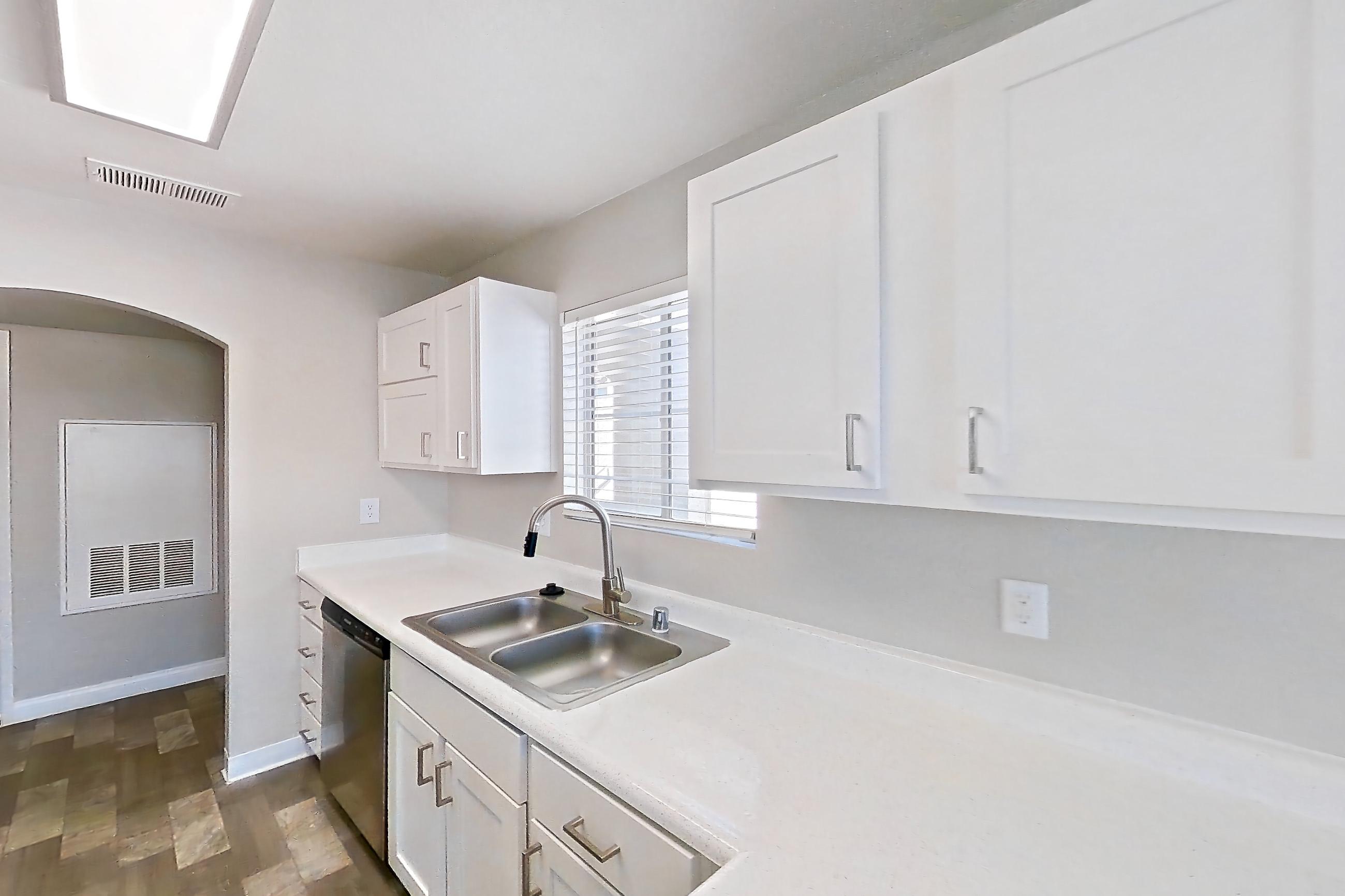 Kitchen with dishwasher, gas range, light countertops, light stone countertops, light wood-finish flooring, microwave, oven/range, refrigerator, stainless steel appliances, and white appliances, Apartment 2089 at Vintage Pointe