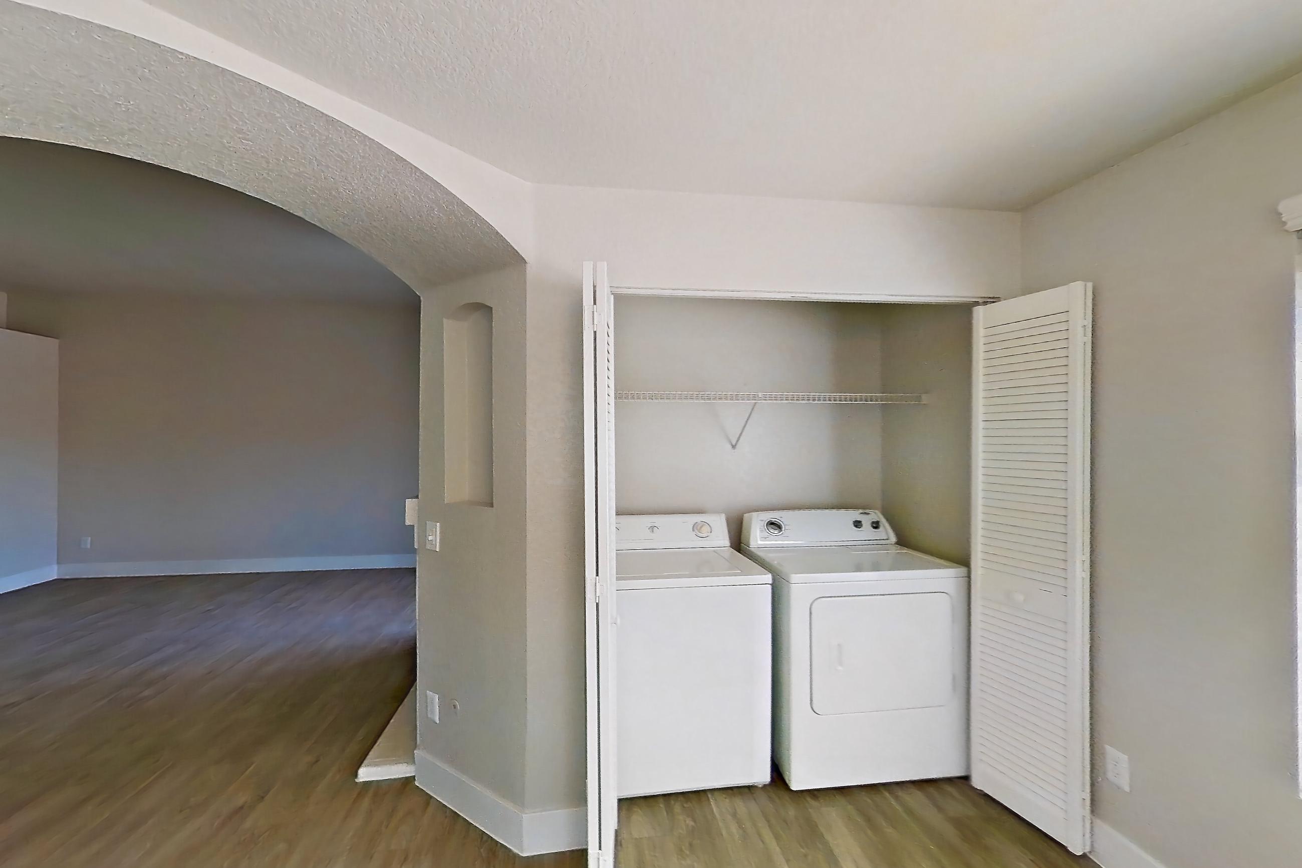 Dining room with dark wood-finish flooring, in-unit laundry, light countertops, and light wood-finish flooring, Apartment 2146 at Vintage Pointe