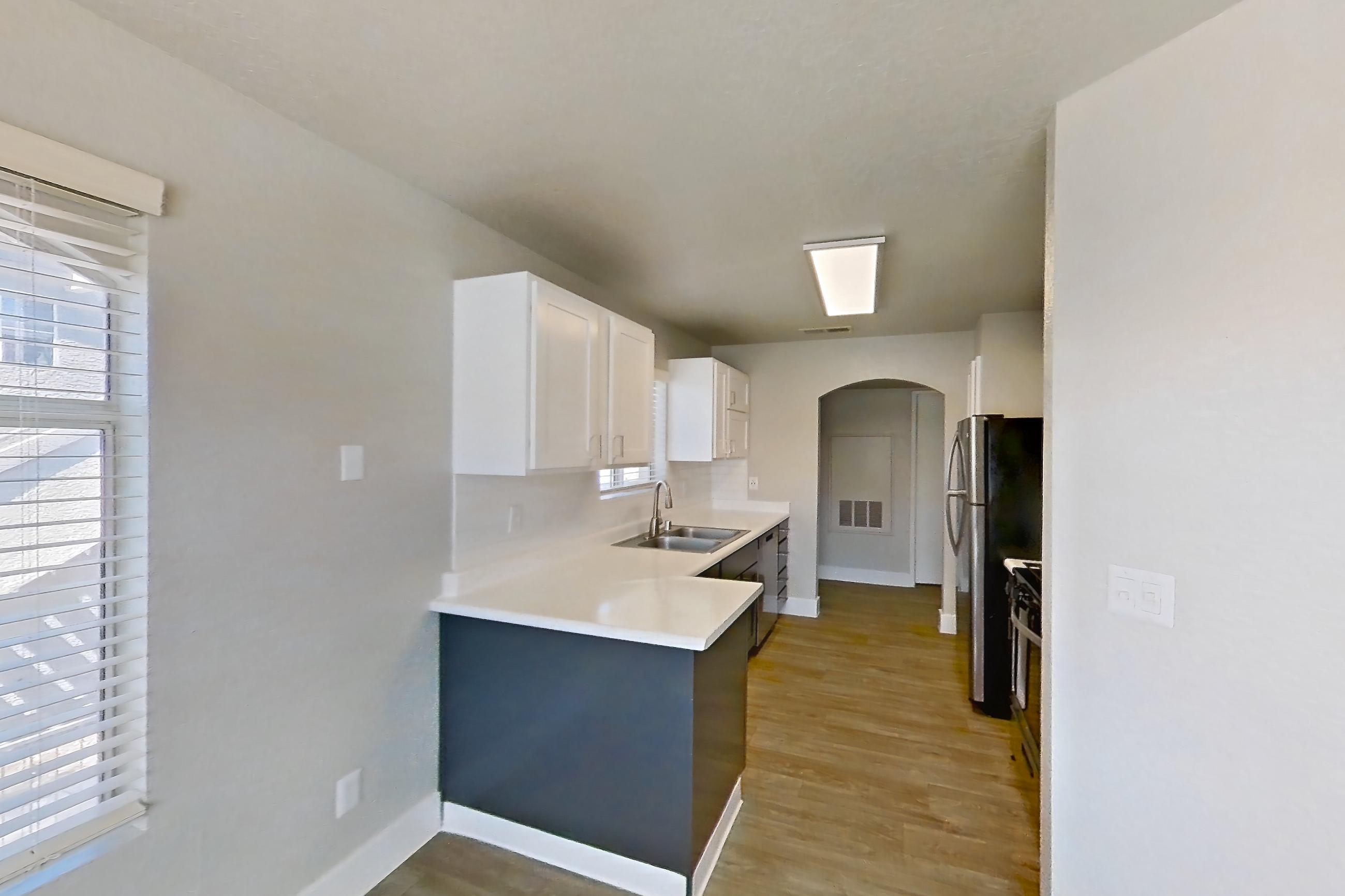 Dining room with dark wood-finish flooring, in-unit laundry, light countertops, and light wood-finish flooring, Apartment 2146 at Vintage Pointe