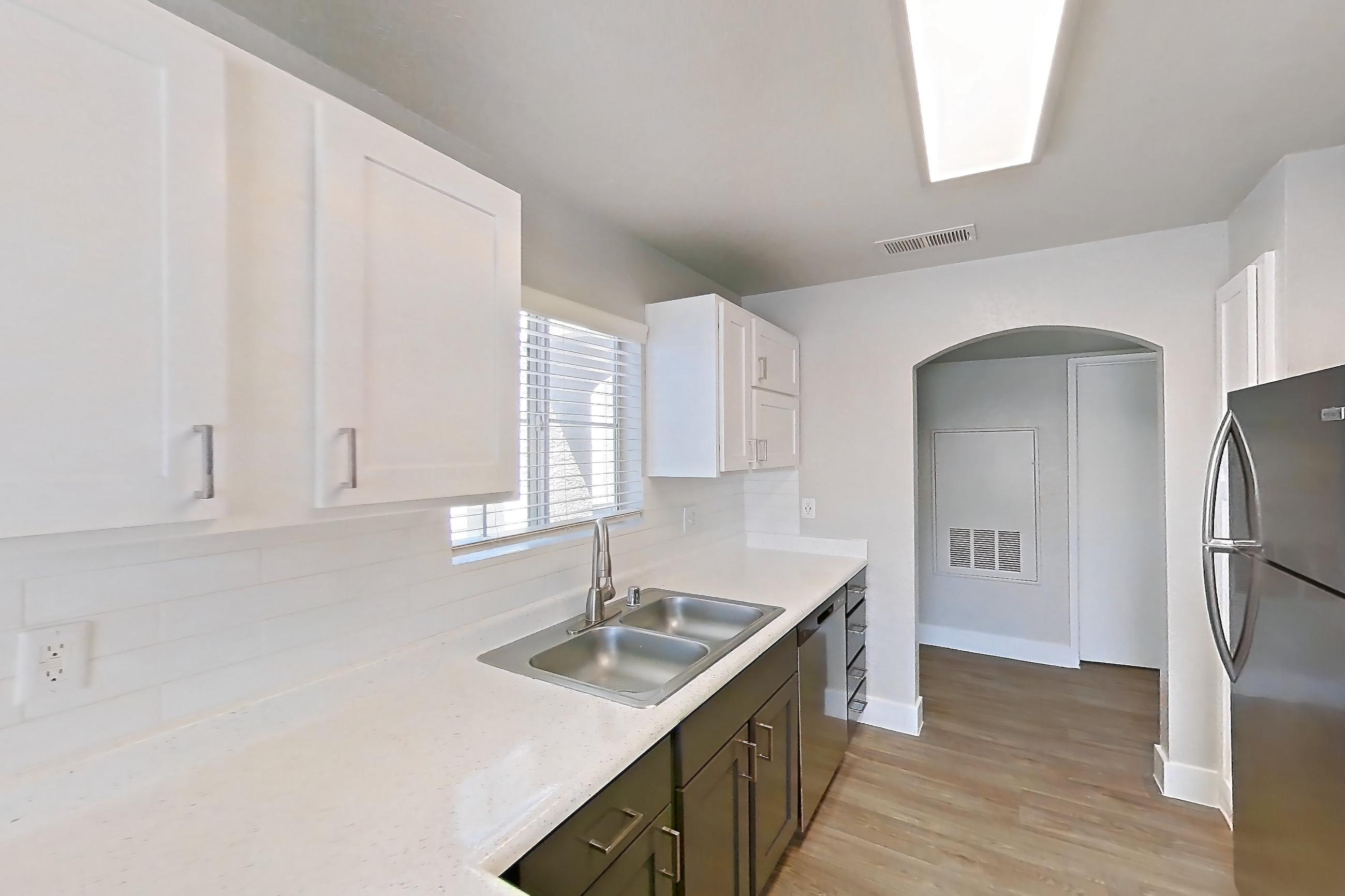 Kitchen with gas range, light countertops, light stone countertops, light wood-finish flooring, microwave, oven/range, refrigerator, and stainless steel appliances, Apartment 2146 at Vintage Pointe