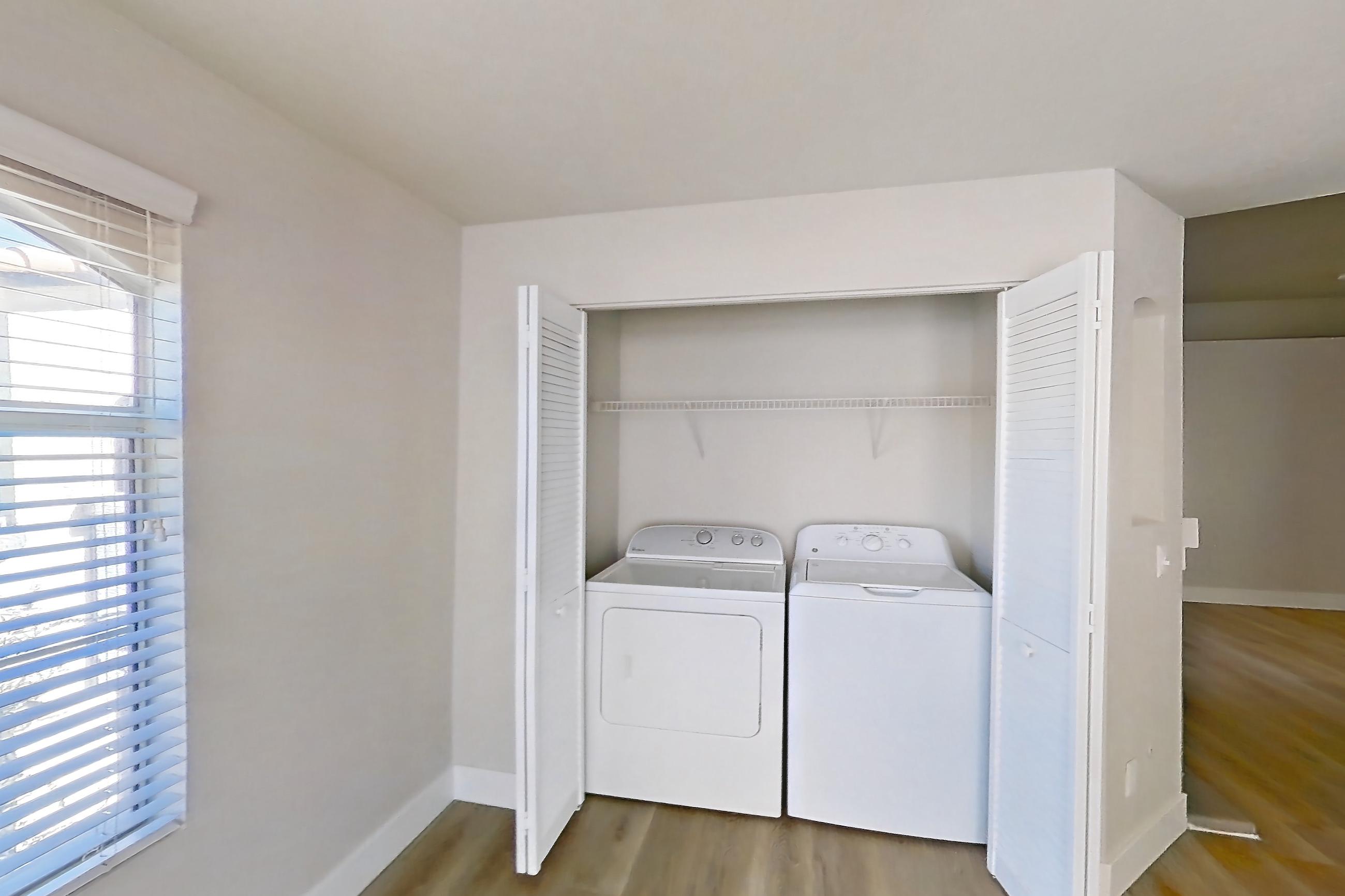 Dining room with in-unit laundry, light countertops, light wood-finish flooring, refrigerator, and stainless steel appliances, Apartment 2077 at Vintage Pointe