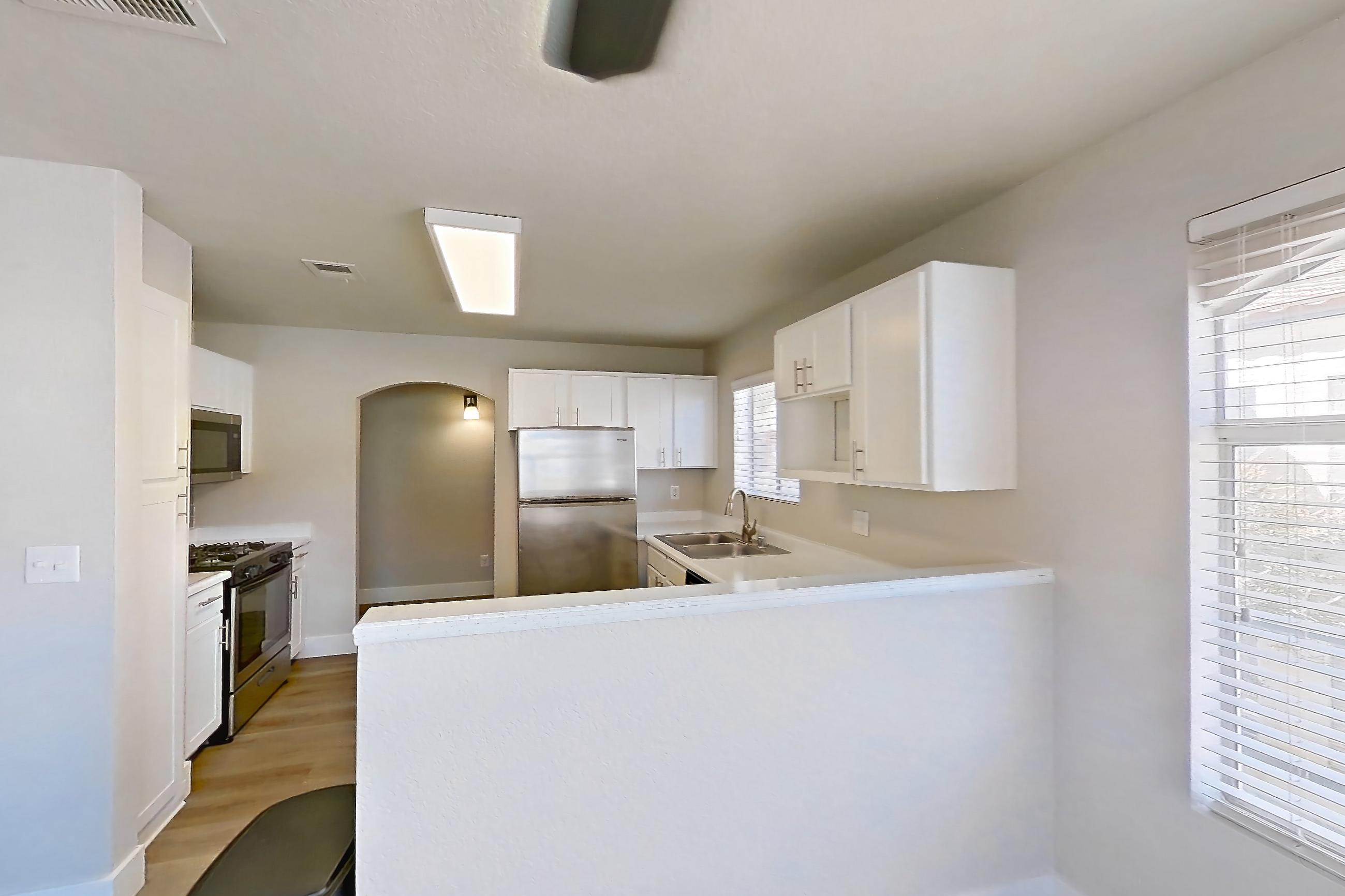 Dining room with in-unit laundry, light countertops, light wood-finish flooring, refrigerator, and stainless steel appliances, Apartment 2077 at Vintage Pointe