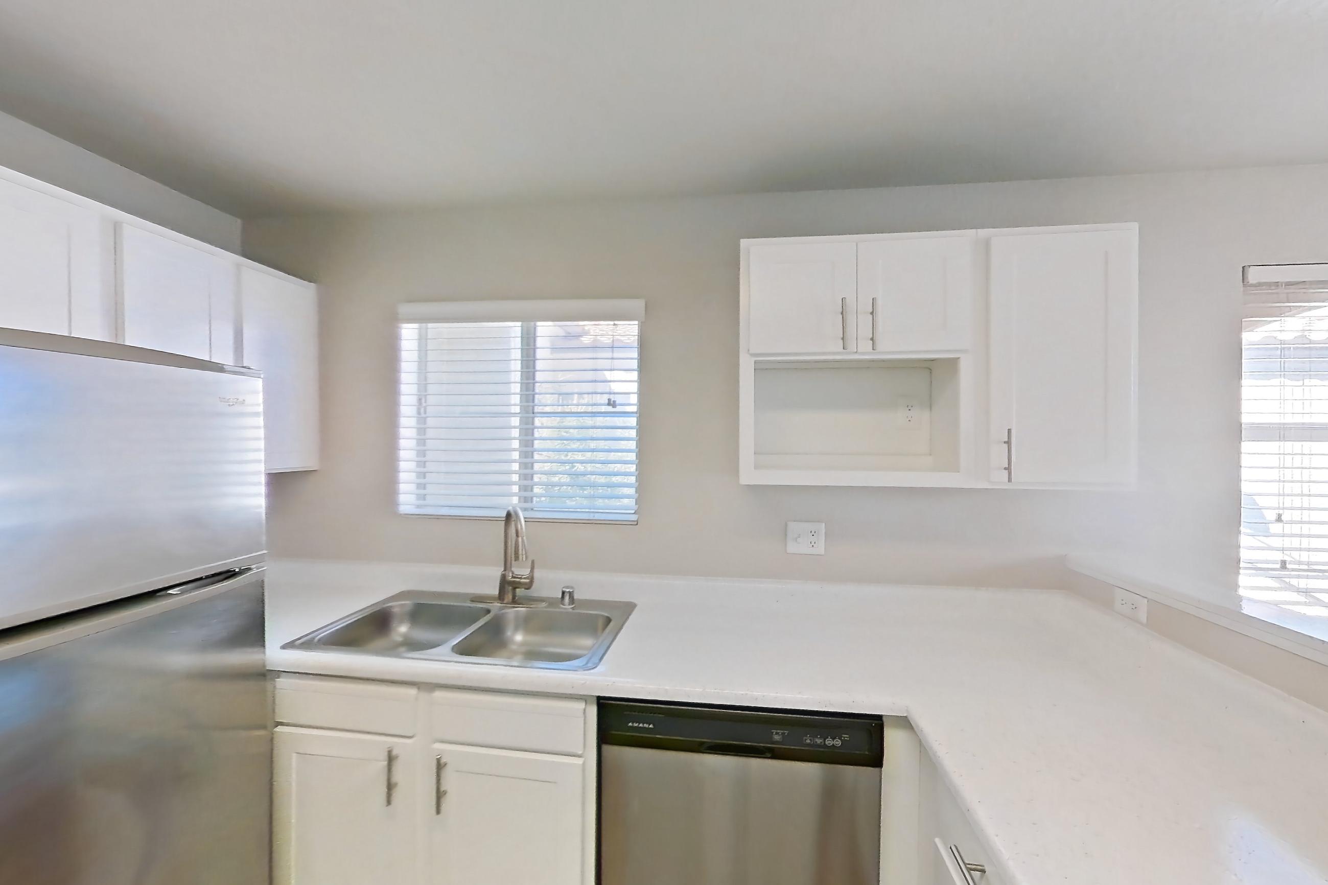 Kitchen with dishwasher, gas range, light countertops, light wood-finish flooring, microwave, oven/range, refrigerator, and stainless steel appliances, Apartment 2077 at Vintage Pointe