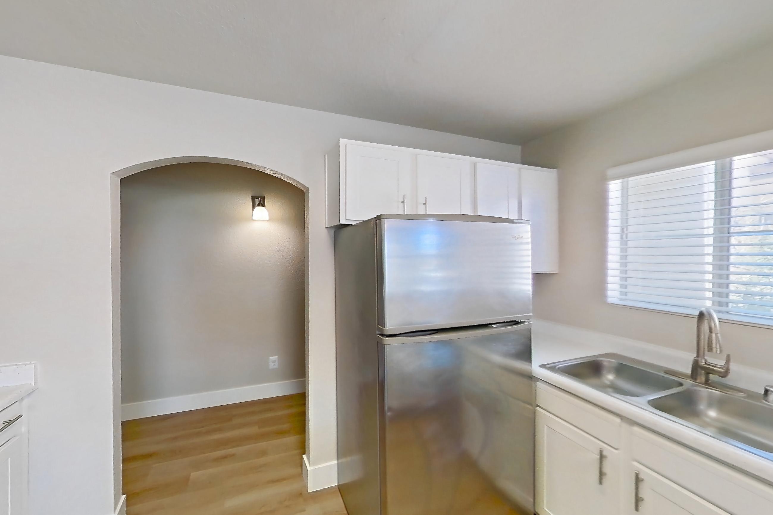 Kitchen with dishwasher, gas range, light countertops, light wood-finish flooring, microwave, oven/range, refrigerator, and stainless steel appliances, Apartment 2077 at Vintage Pointe