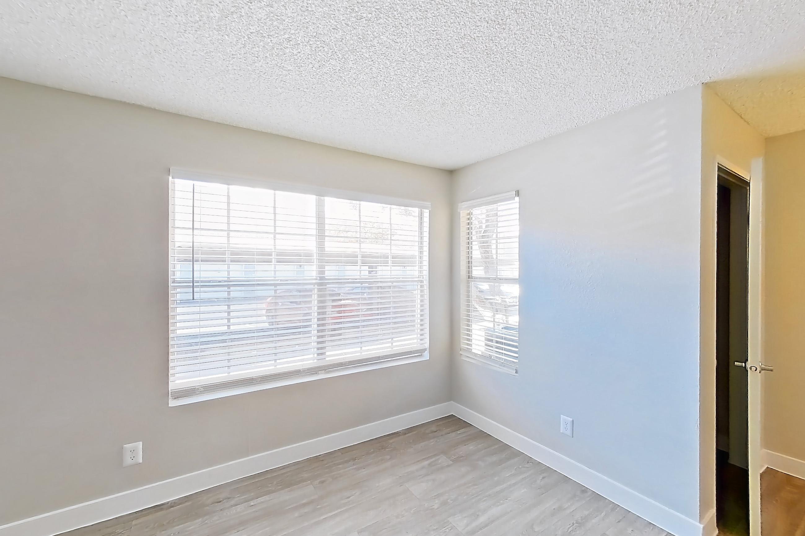 Living room with dishwasher, light countertops, light wood-finish flooring, refrigerator, and stainless steel appliances, Apartment 1062 at The Met Las Vegas