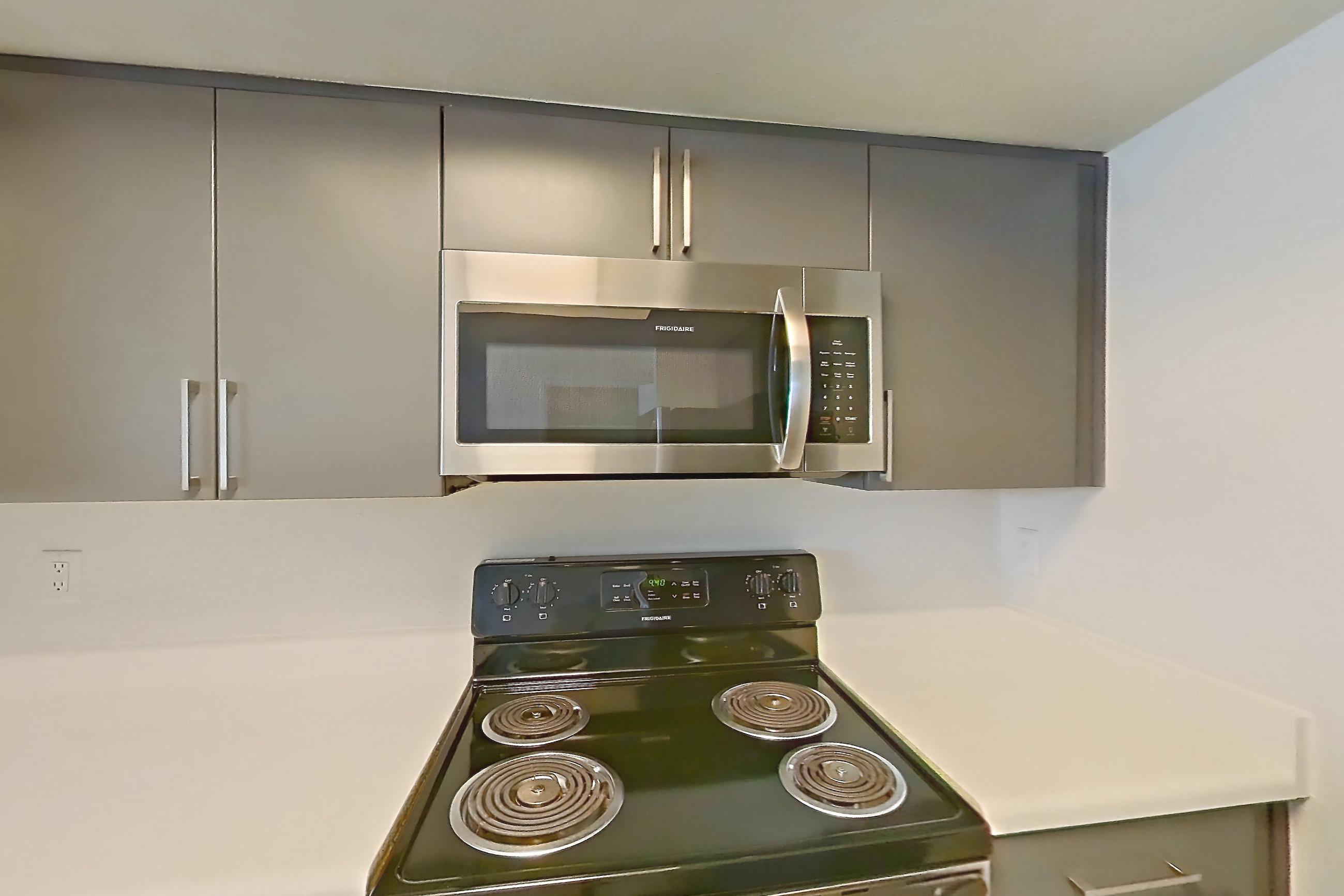 Kitchen with dishwasher, electric range, light countertops, light wood-finish flooring, microwave, oven/range, and stainless steel appliances, Apartment 2091 at The Met Las Vegas