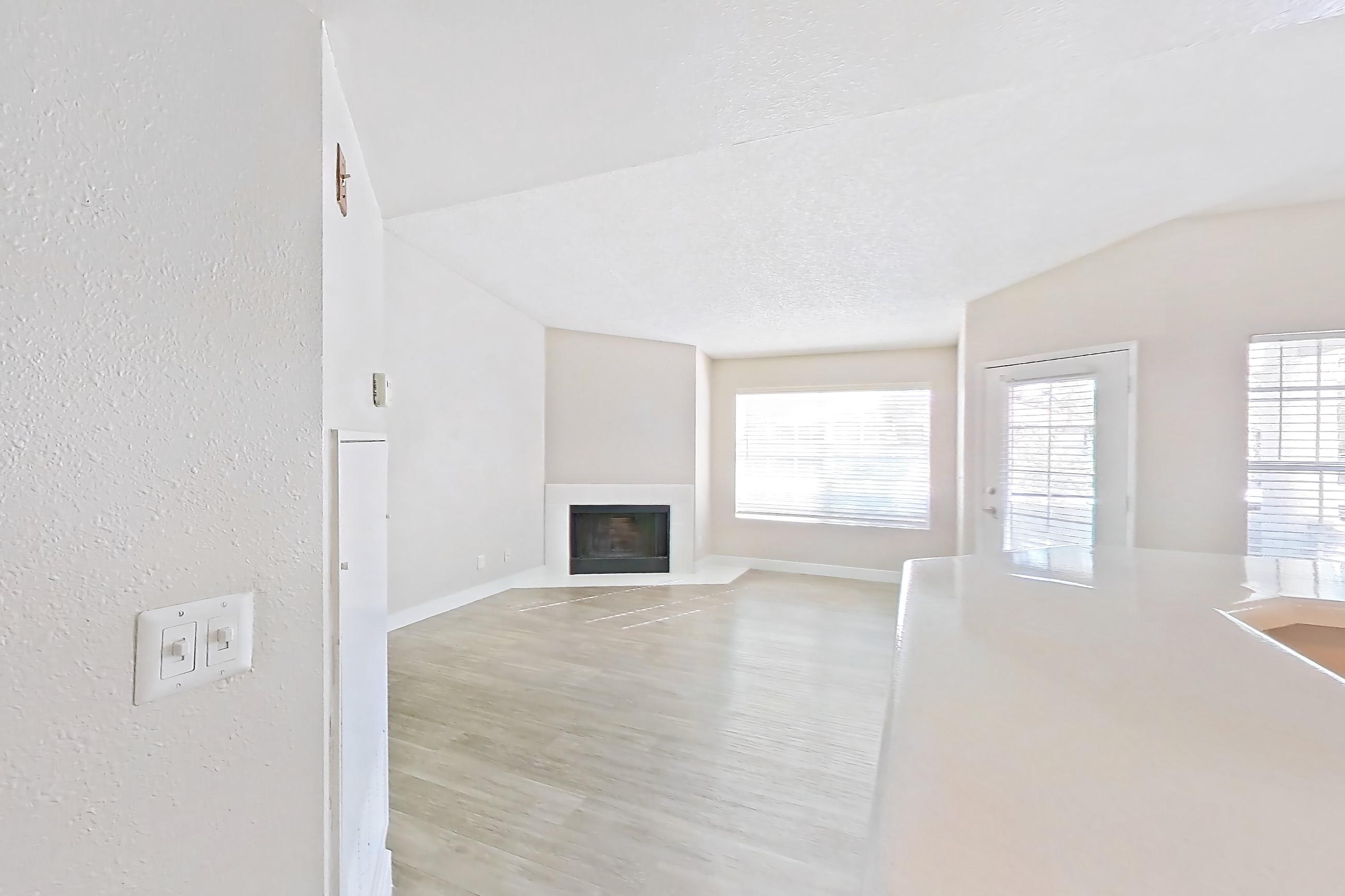 Kitchen with dishwasher, electric range, fireplace, light countertops, light stone countertops, light wood-finish flooring, microwave, oven/range, refrigerator, stainless steel appliances, and tile fireplace, Apartment 2233 at The Met Las Vegas