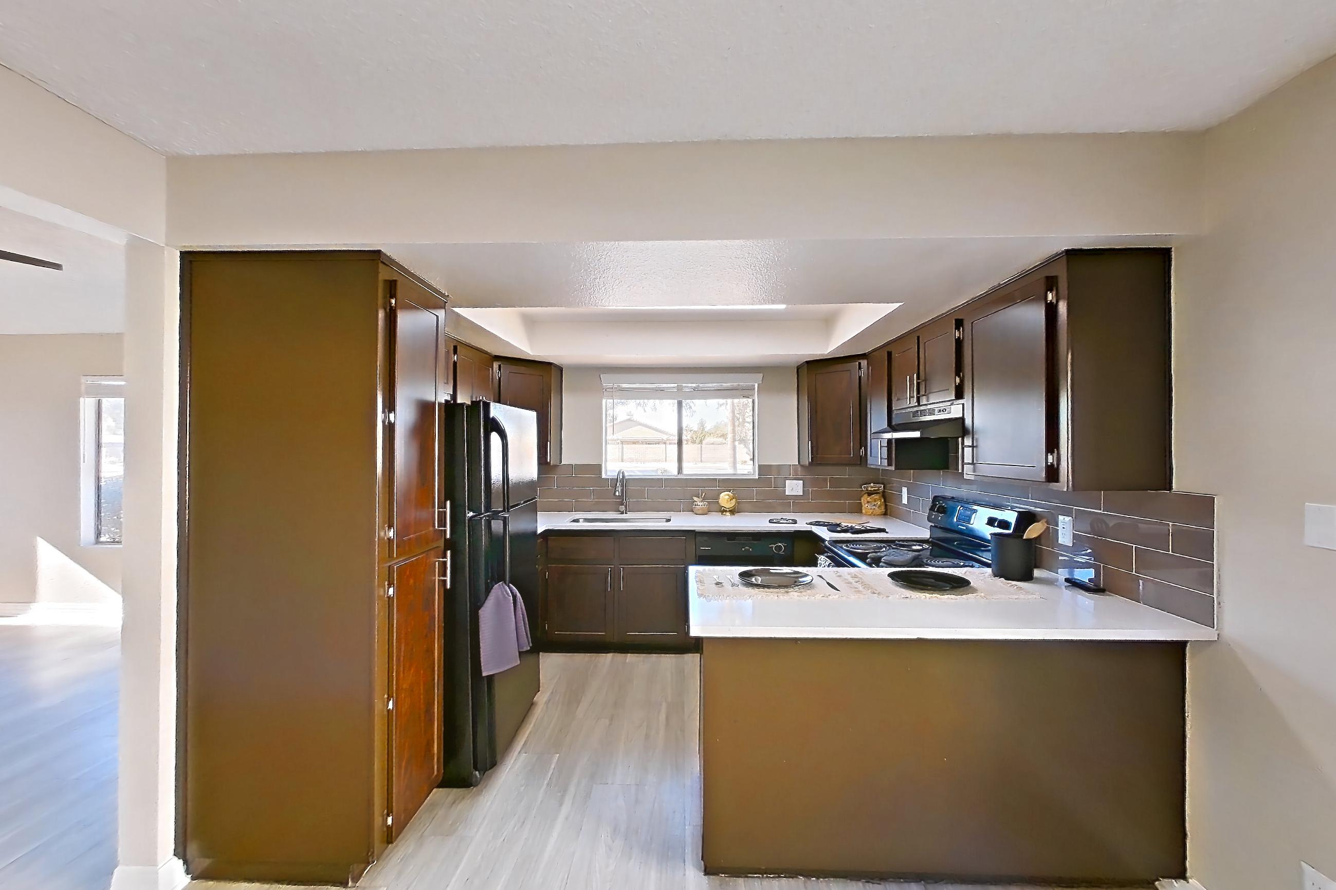 Dining room with black appliances, electric range, light countertops, light wood-finish flooring, oven/range, and refrigerator, Apartment A-1102 at Arches at Hidden Creek