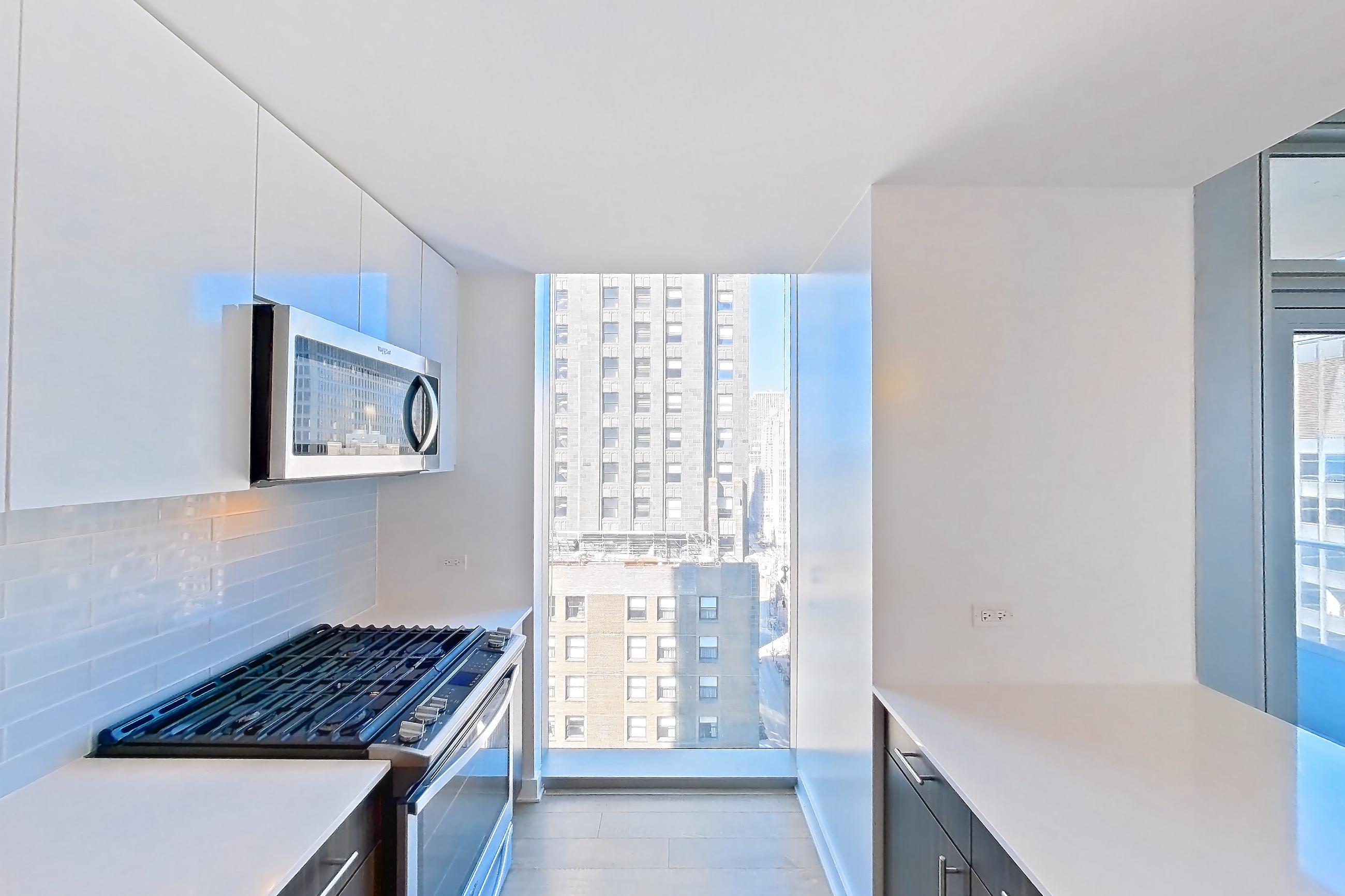 Kitchen with dishwasher, gas range, light countertops, light wood-finish flooring, oven/range, and stainless steel appliances, Apartment 3104 at Mila