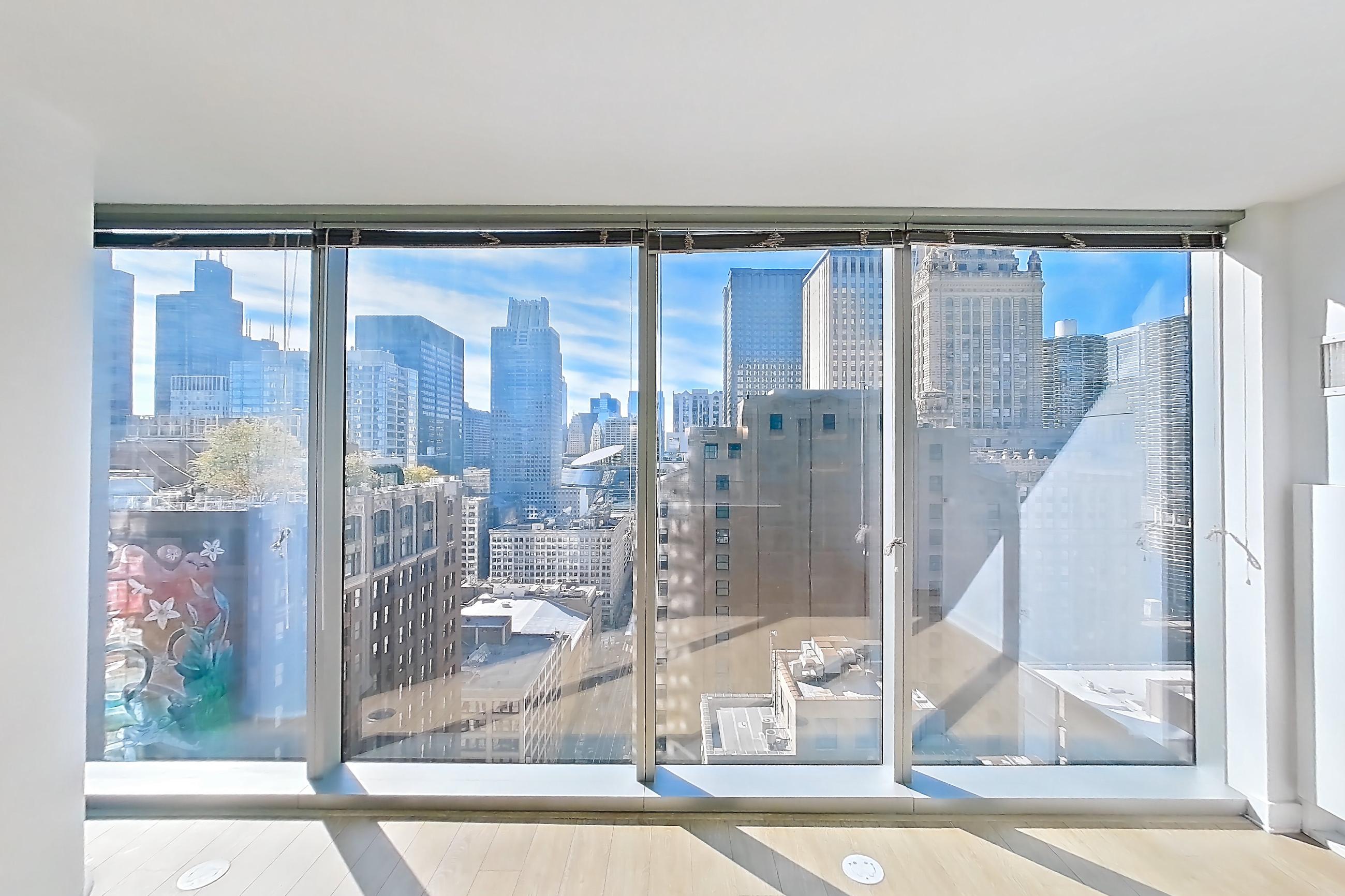 Living room with city view, light wood-finish flooring, and skyline view, Apartment 2810 at Mila
