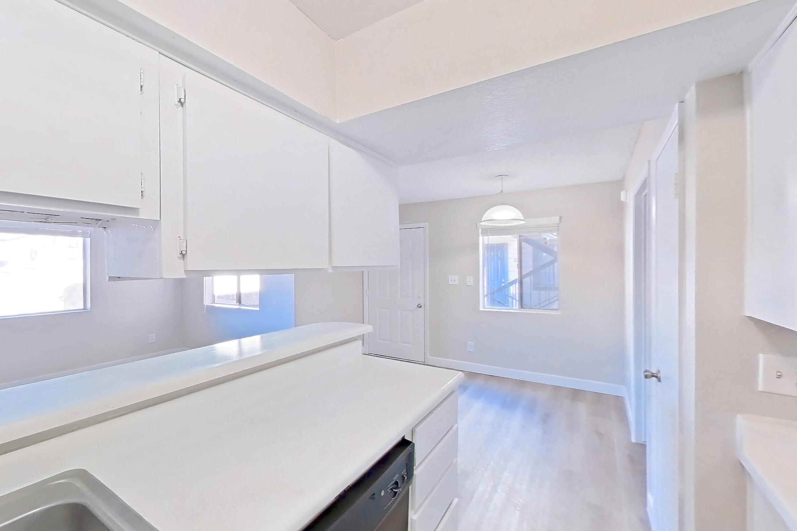 Kitchen with black appliances, dishwasher, electric range, light countertops, light wood-finish flooring, oven/range, and stainless steel appliances, Apartment 2079 at Terra Vida Apartments