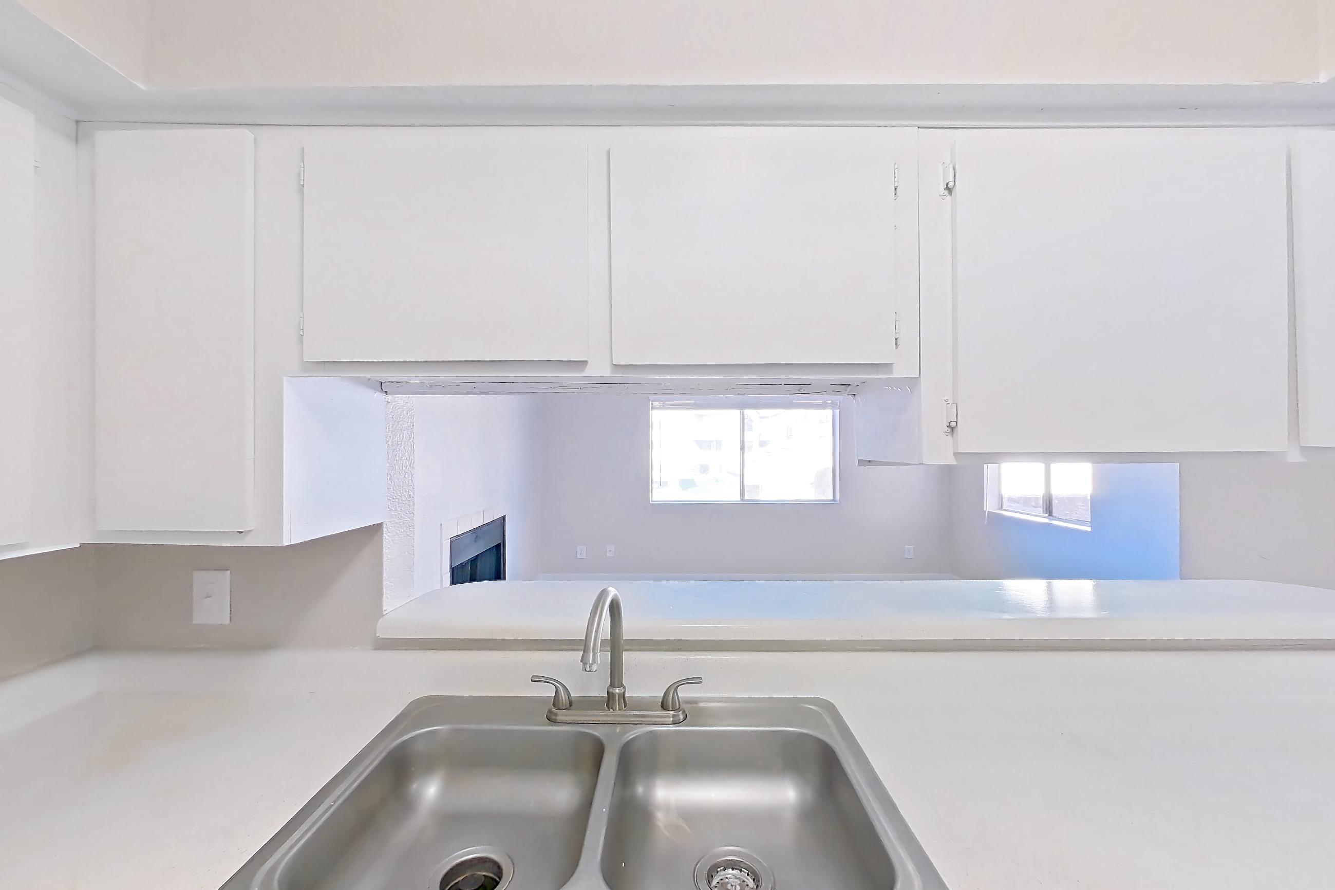 Kitchen with black appliances, dishwasher, electric range, light countertops, light wood-finish flooring, oven/range, and stainless steel appliances, Apartment 2079 at Terra Vida Apartments