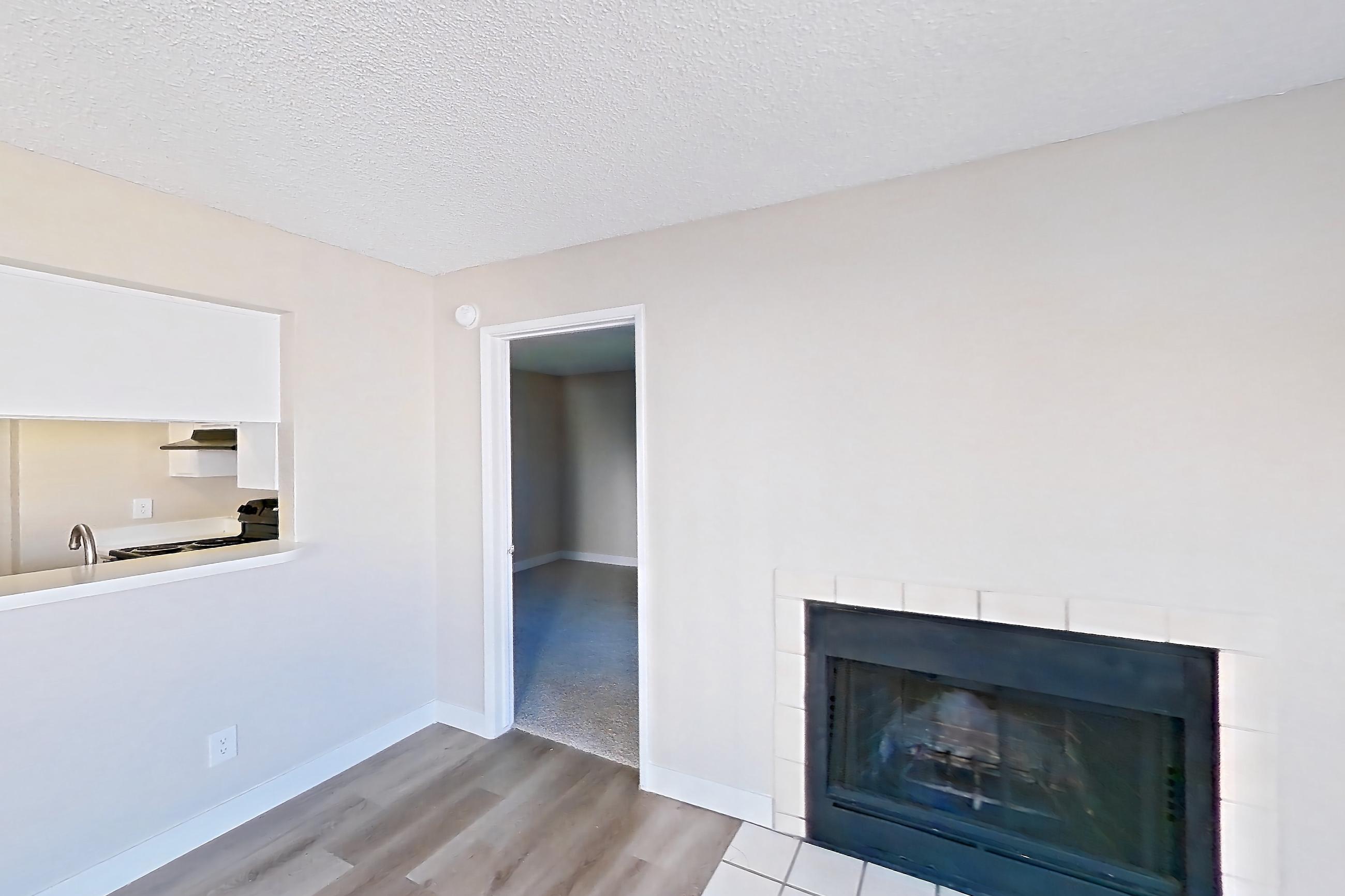 Living room with fireplace, light wood-finish flooring, oven/range, refrigerator, tile fireplace, and white appliances, Apartment 2079 at Terra Vida Apartments