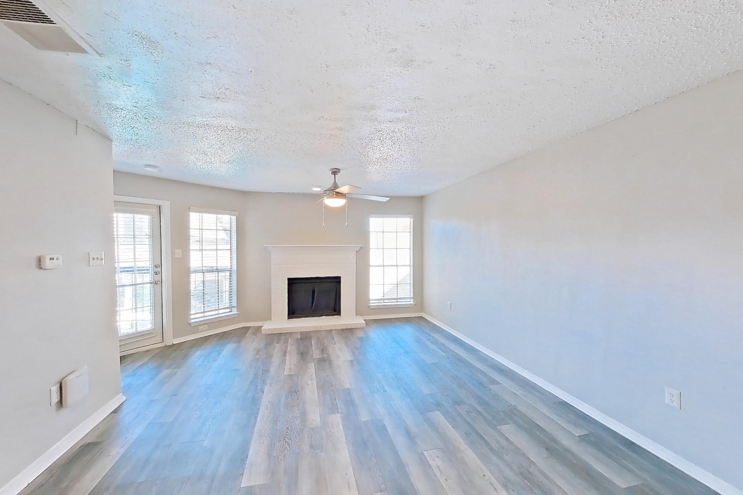 Dining room with fireplace and light wood-finish flooring, Apartment 06-0624 at The Arbors of Las Colinas