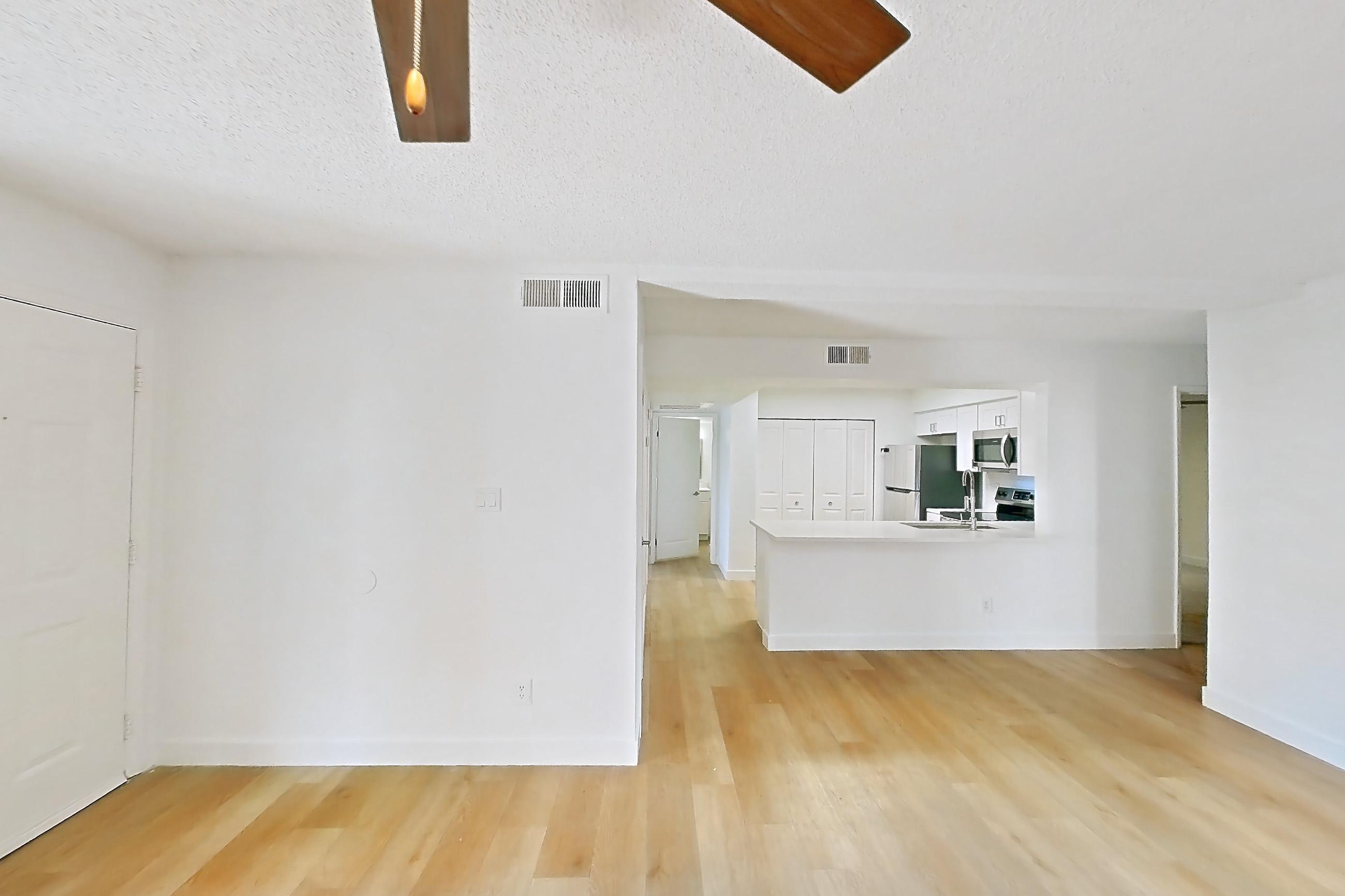 Living room with light wood-finish flooring, oven/range, and stainless steel appliances, Apartment 1091 at Terra Vida Apartments