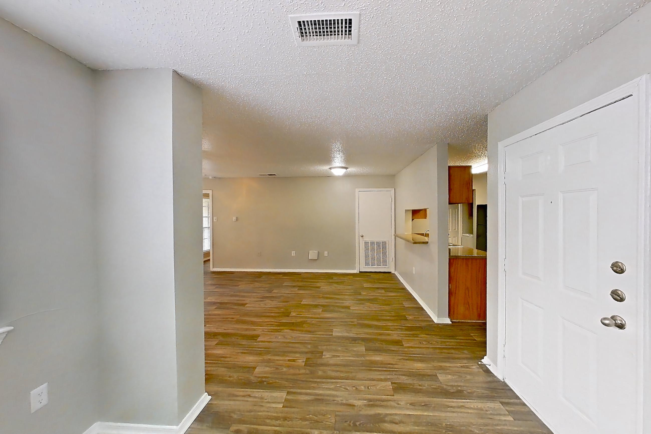 Living space with dark wood-finish flooring, Apartment 14-1411 at The Arbors of Las Colinas