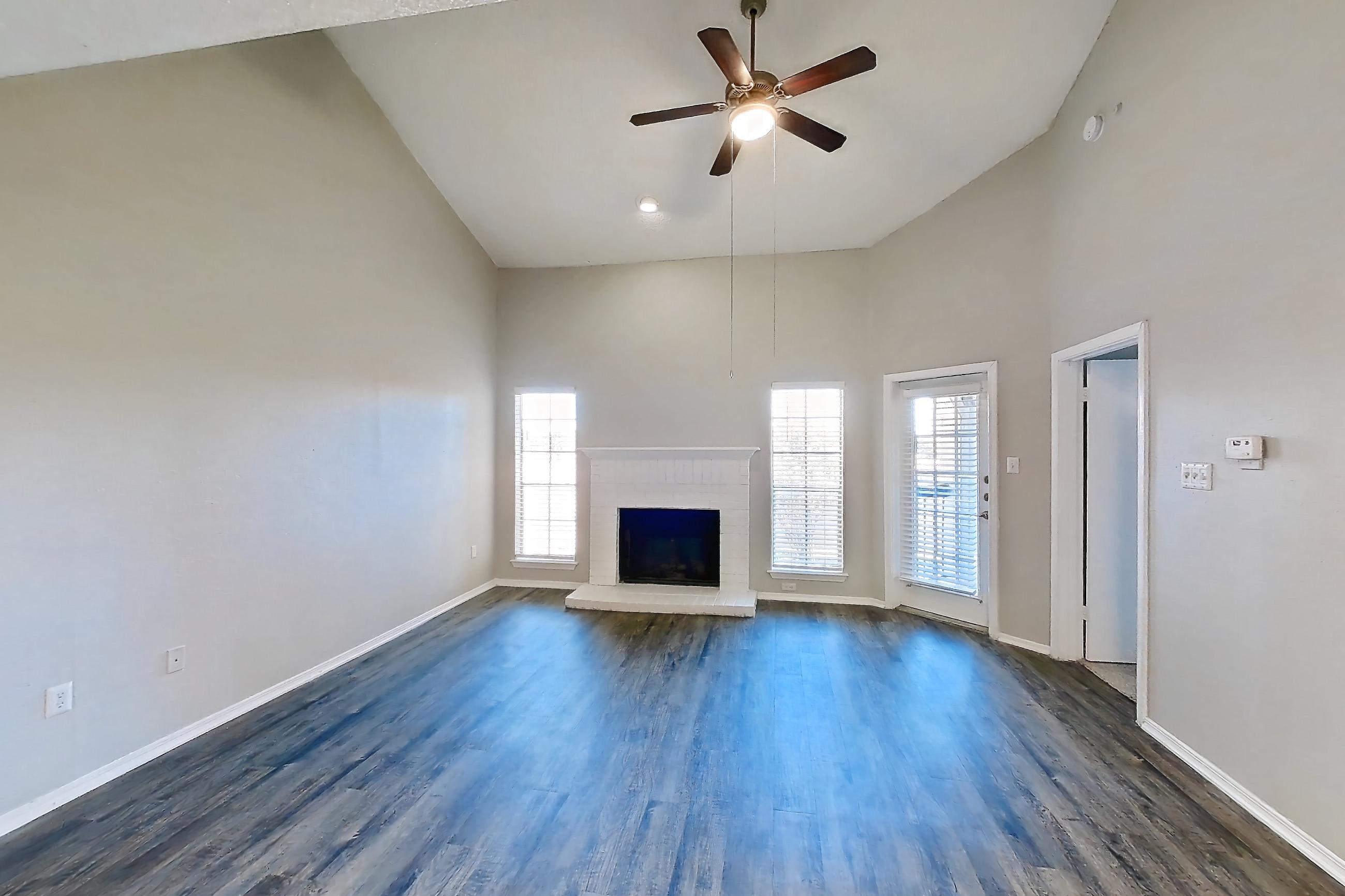 Dining room with brick fireplace, dark wood-finish flooring, and fireplace, Apartment 05-0521 at The Arbors of Las Colinas