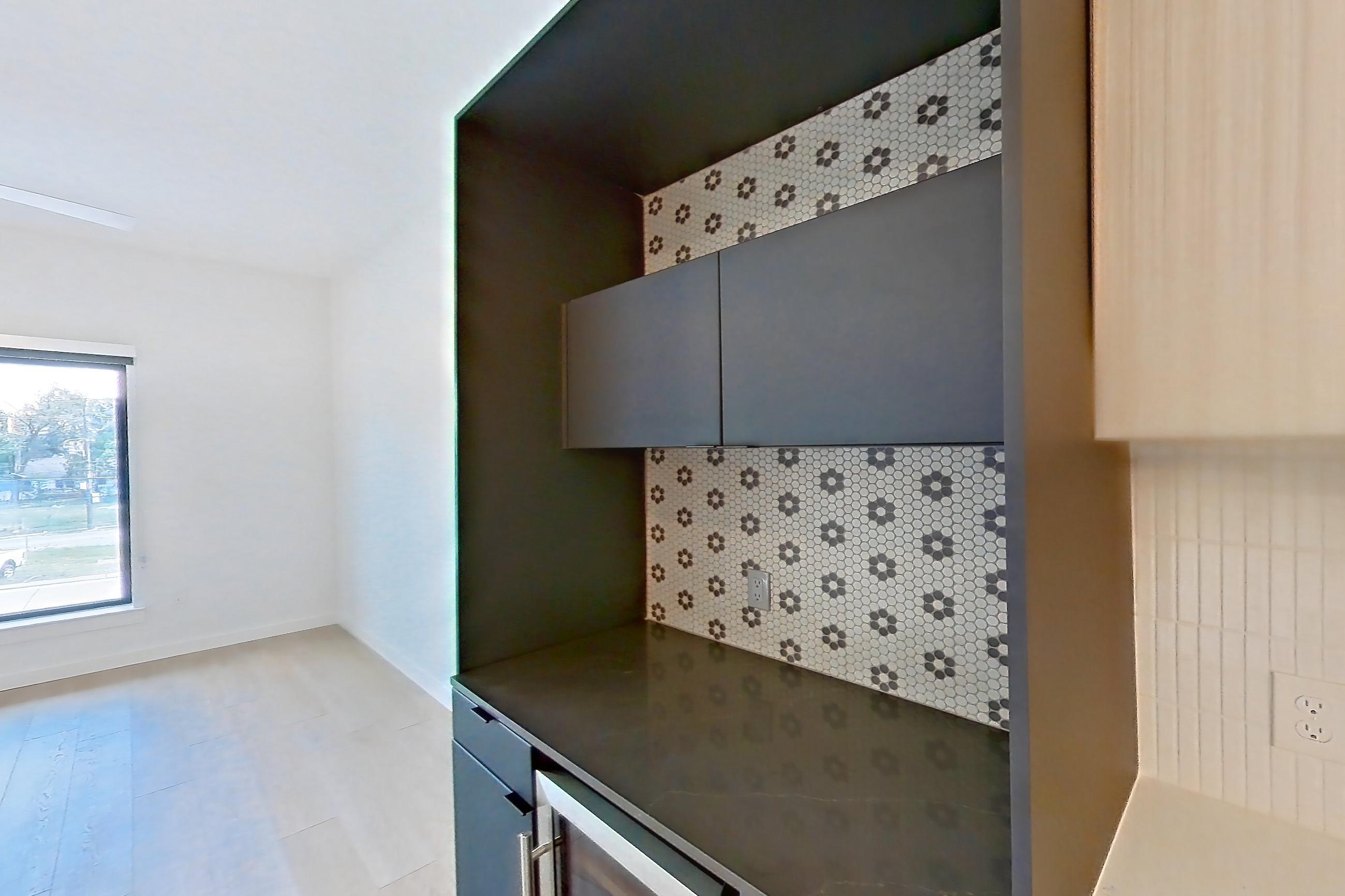 Kitchen with dark countertops, gas range, light stone countertops, light wood-finish flooring, oven/range, refrigerator, and stainless steel appliances, Apartment 0211 at Tempo at White Oak