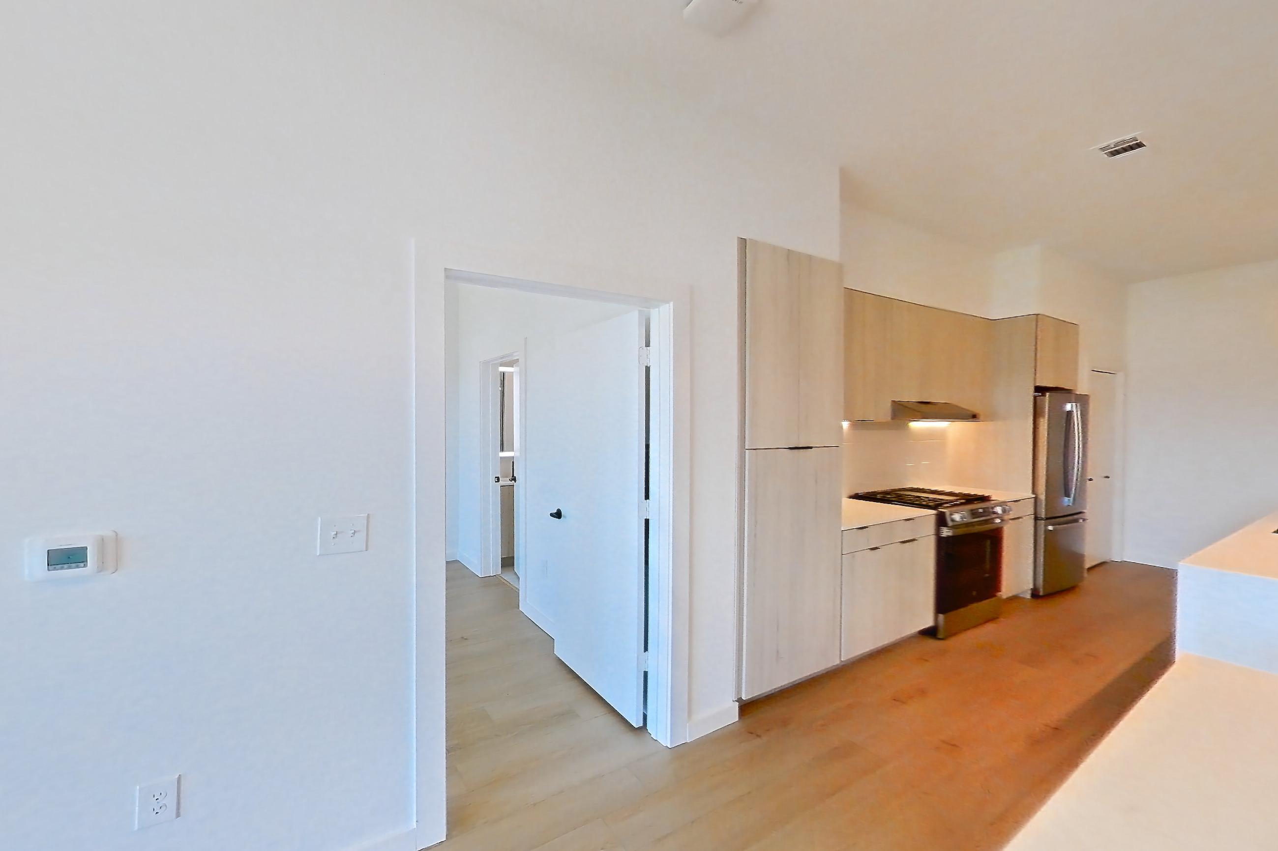 Living room with gas range, light stone countertops, light wood-finish flooring, oven/range, refrigerator, and stainless steel appliances, Apartment 0445 at Tempo at White Oak