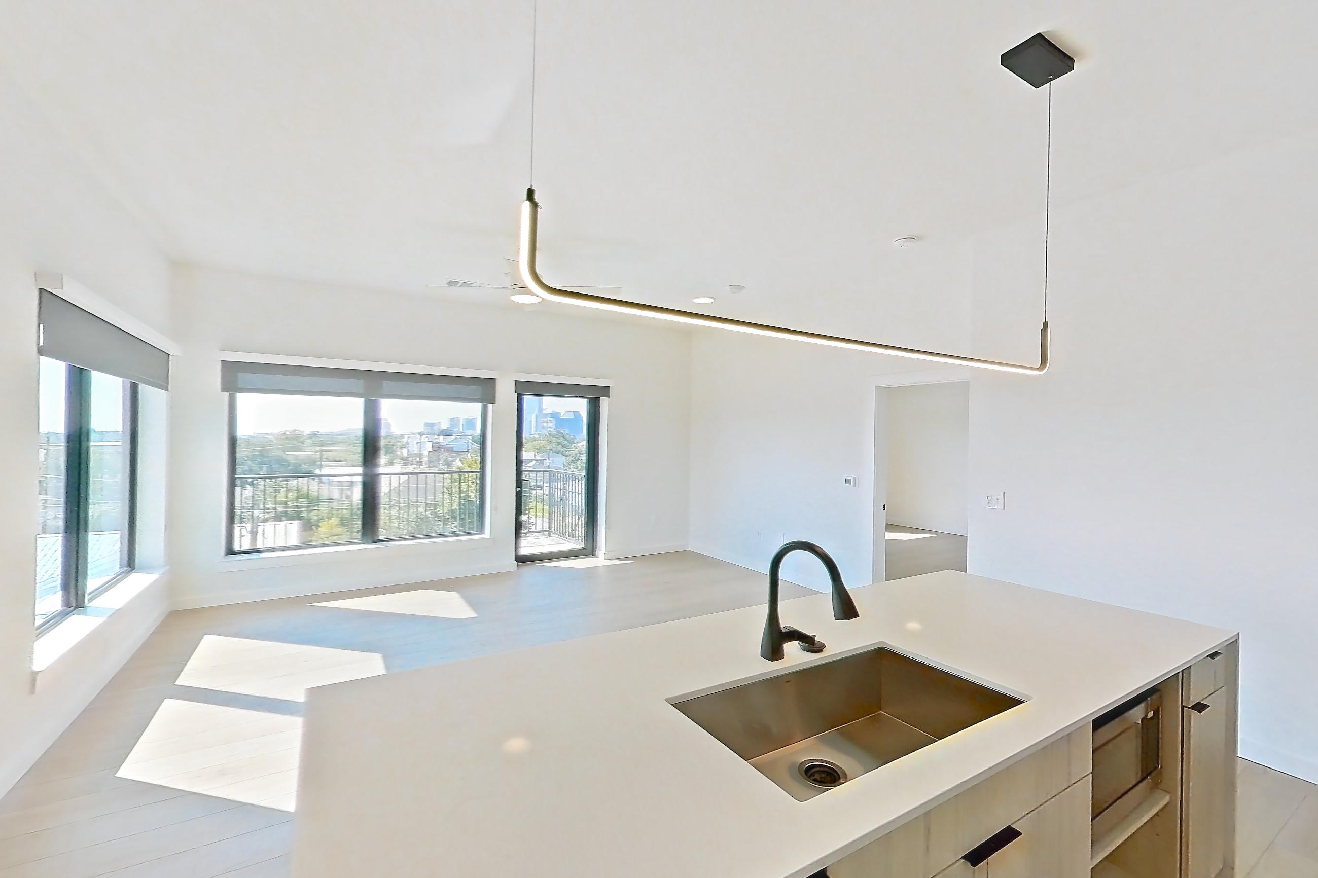 Kitchen with dishwasher, gas range, light stone countertops, light tile flooring, light wood-finish flooring, oven/range, and stainless steel appliances, Apartment 0401 at Tempo at White Oak