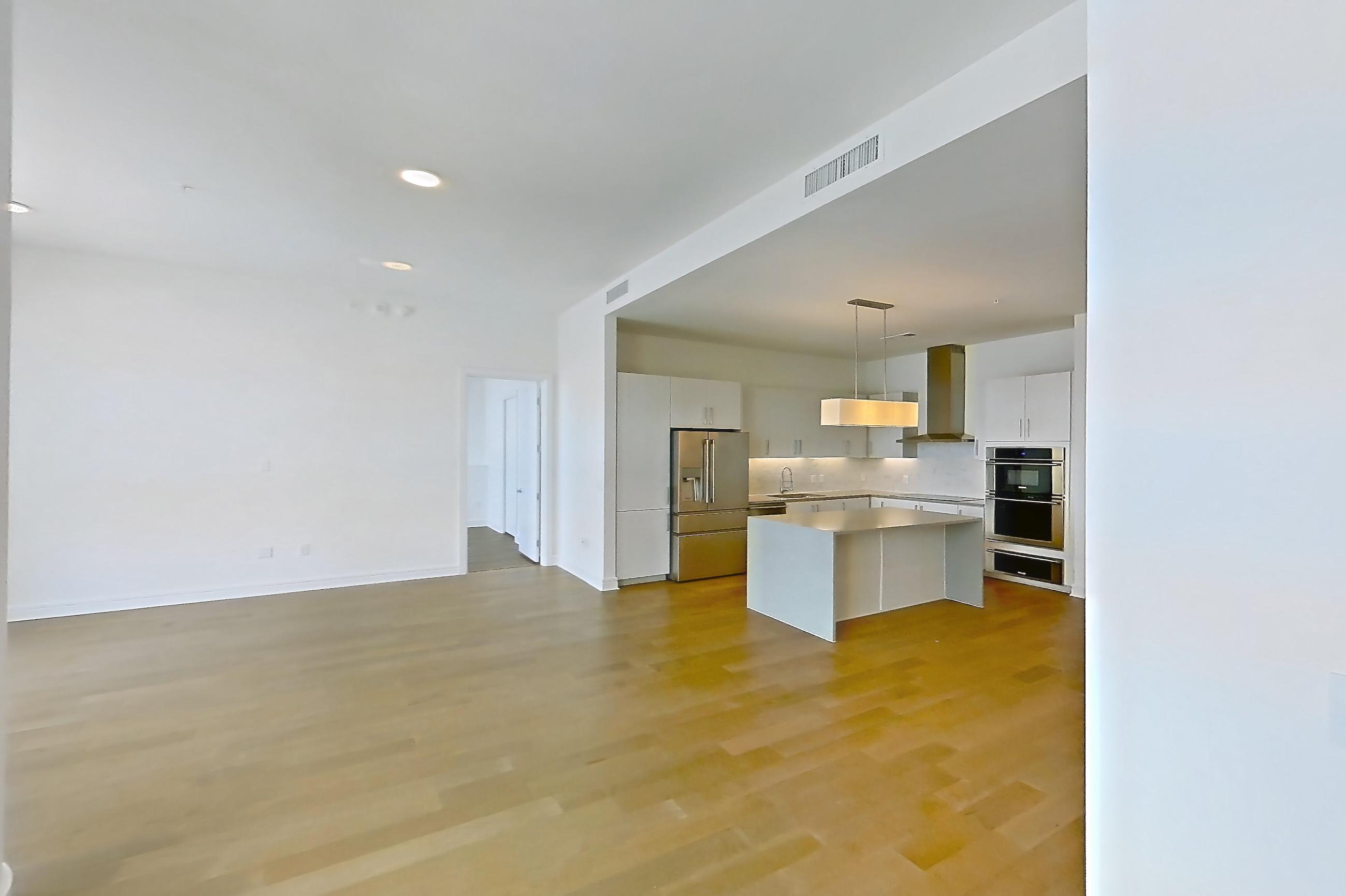 Living space 2 with refrigerator and stainless steel appliances, Apartment 3004 at Luminary Residences