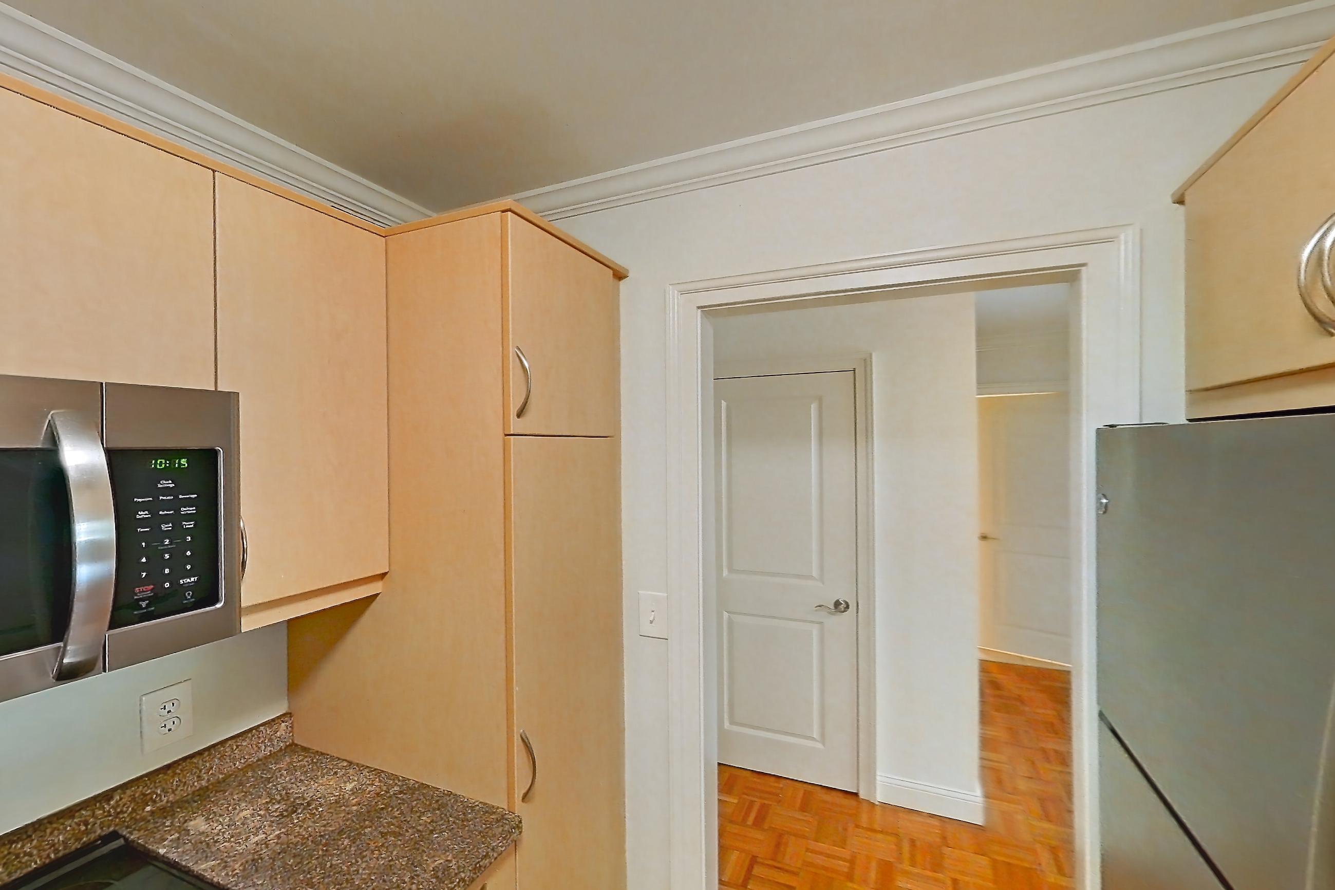 Kitchen with dark stone countertops, dishwasher, electric range, light tile flooring, light wood-finish flooring, oven/range, parquet flooring, refrigerator, and stainless steel appliances, Apartment 199-0208 at Church Park
