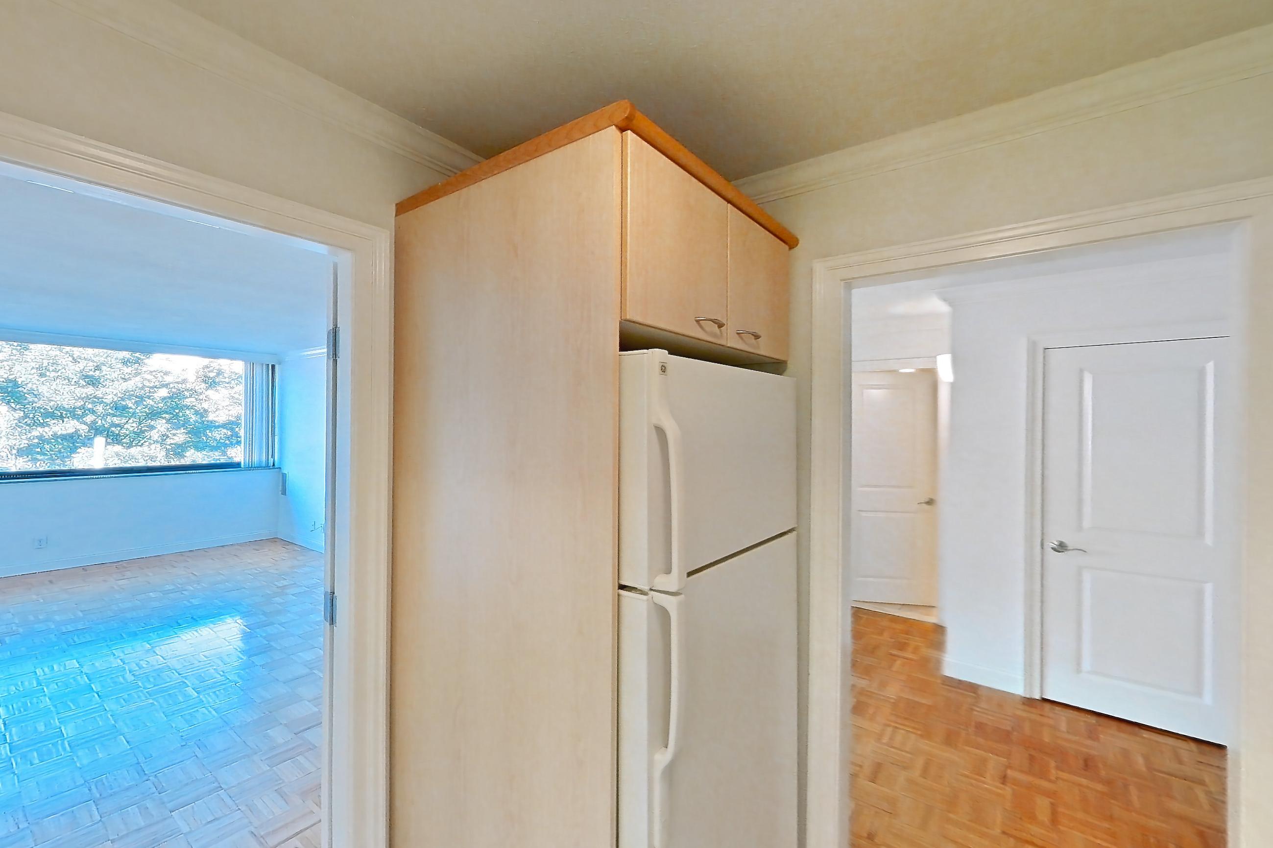 Kitchen with dark stone countertops, dishwasher, electric range, light stone countertops, light tile flooring, light wood-finish flooring, oven/range, parquet flooring, refrigerator, and white appliances, Apartment 199-0304 at Church Park