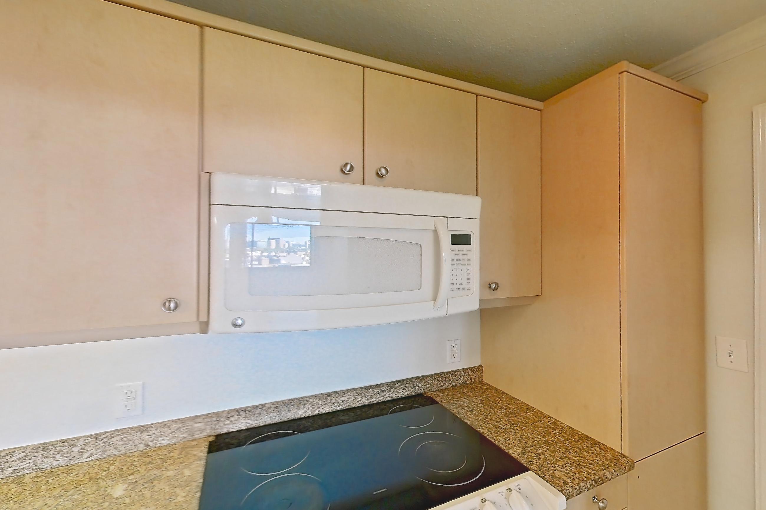 Kitchen with dishwasher, electric range, light stone countertops, light tile flooring, light wood-finish flooring, microwave, oven/range, and white appliances, Apartment 255-0906 at Church Park