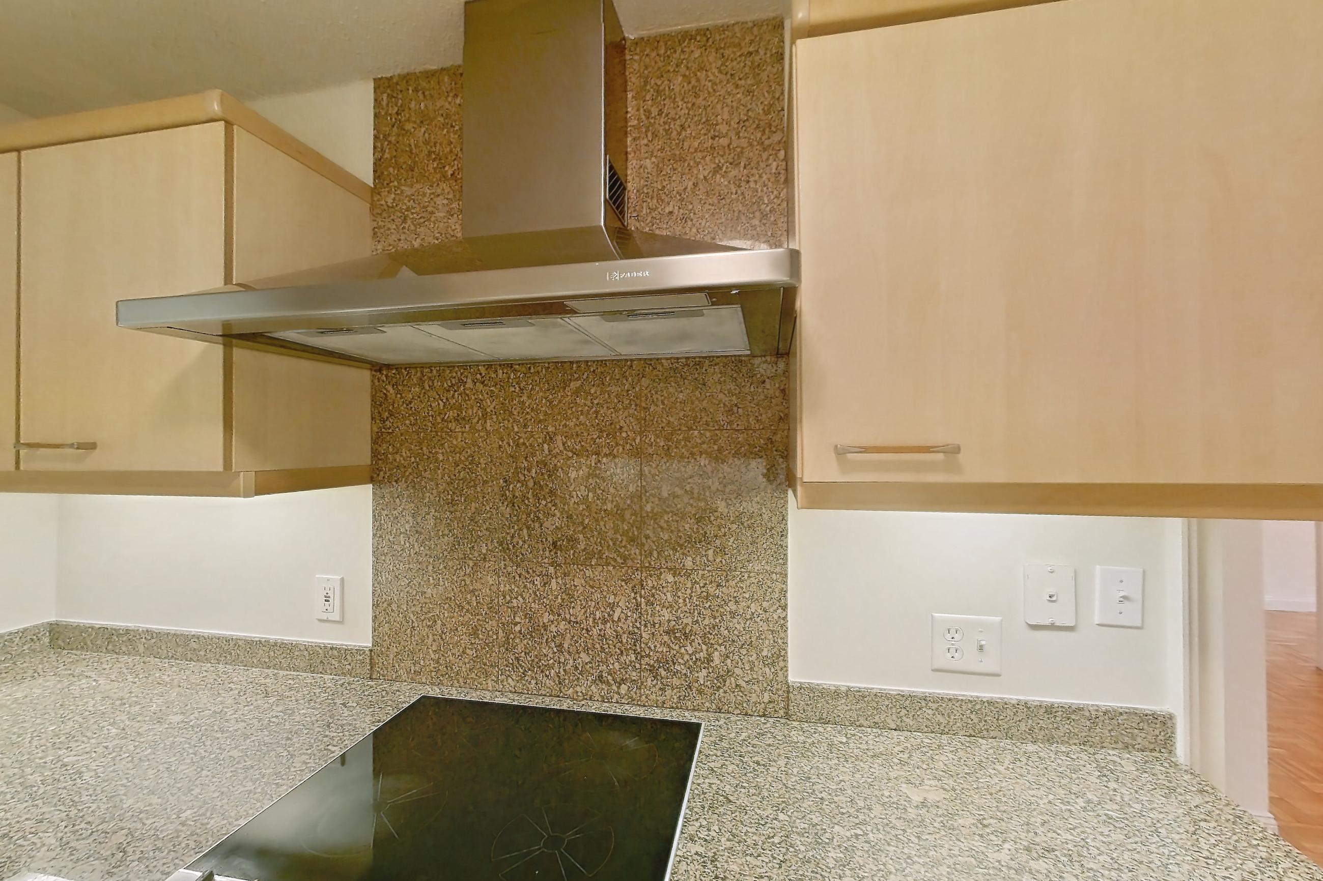 Kitchen with black appliances, cooktop, electric cooktop, light stone countertops, light tile flooring, oven/range, and range hood, Apartment 255-0318 at Church Park