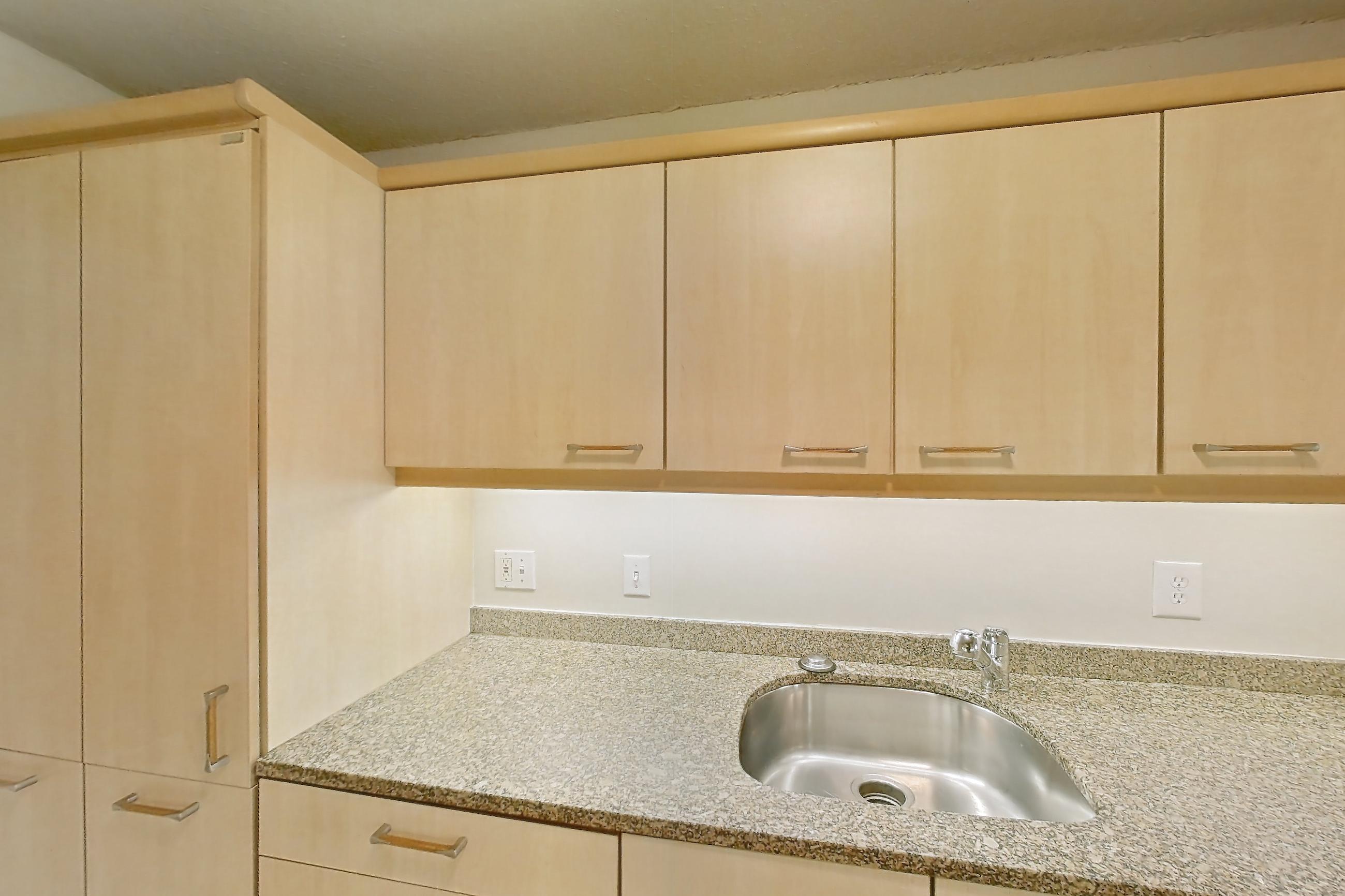 Kitchen with black appliances, cooktop, electric cooktop, light stone countertops, light tile flooring, oven/range, and range hood, Apartment 255-0318 at Church Park