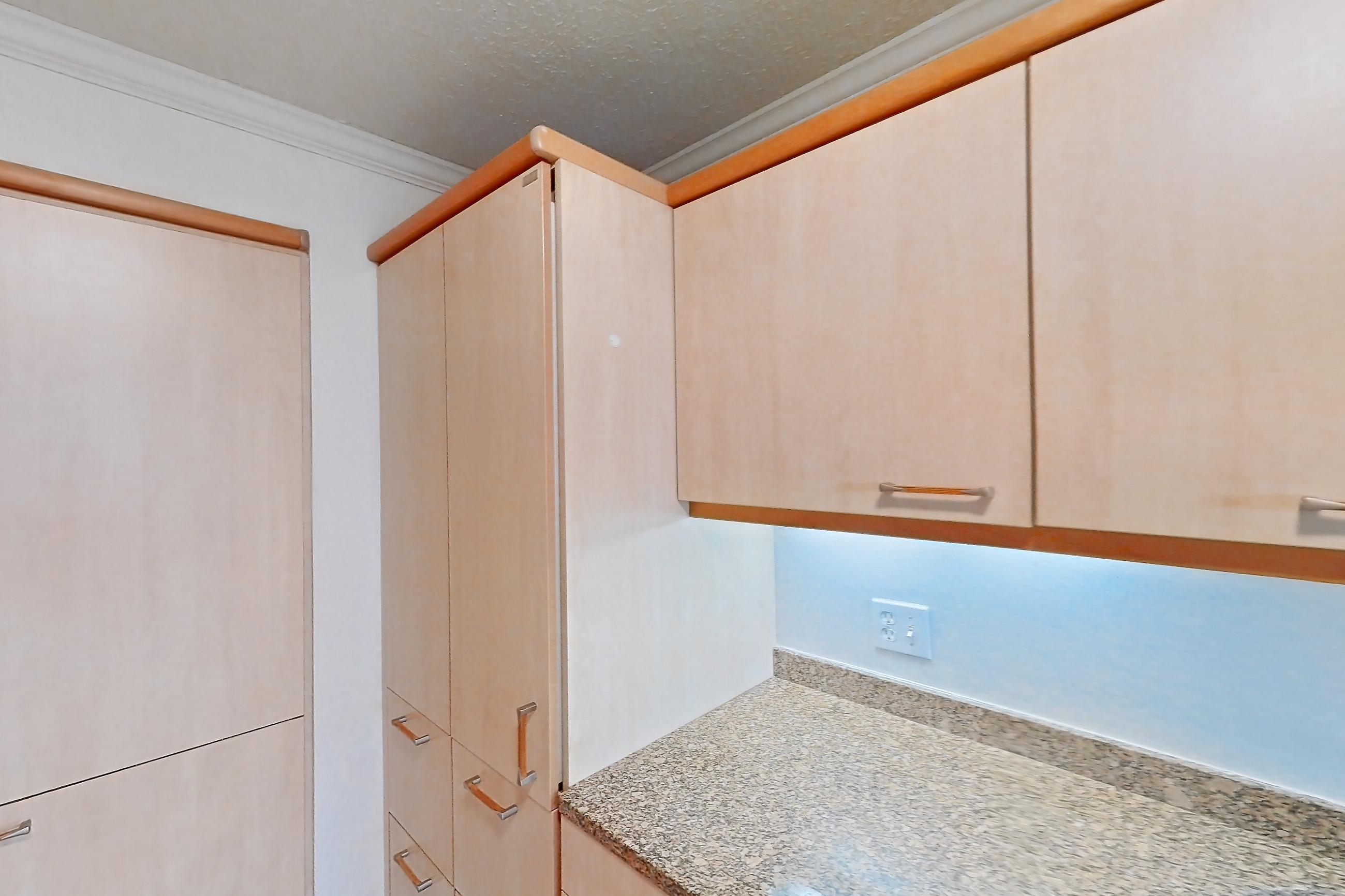 Kitchen with black appliances, cooktop, dark stone countertops, electric cooktop, light stone countertops, light tile flooring, and range hood, Apartment 255-0518 at Church Park
