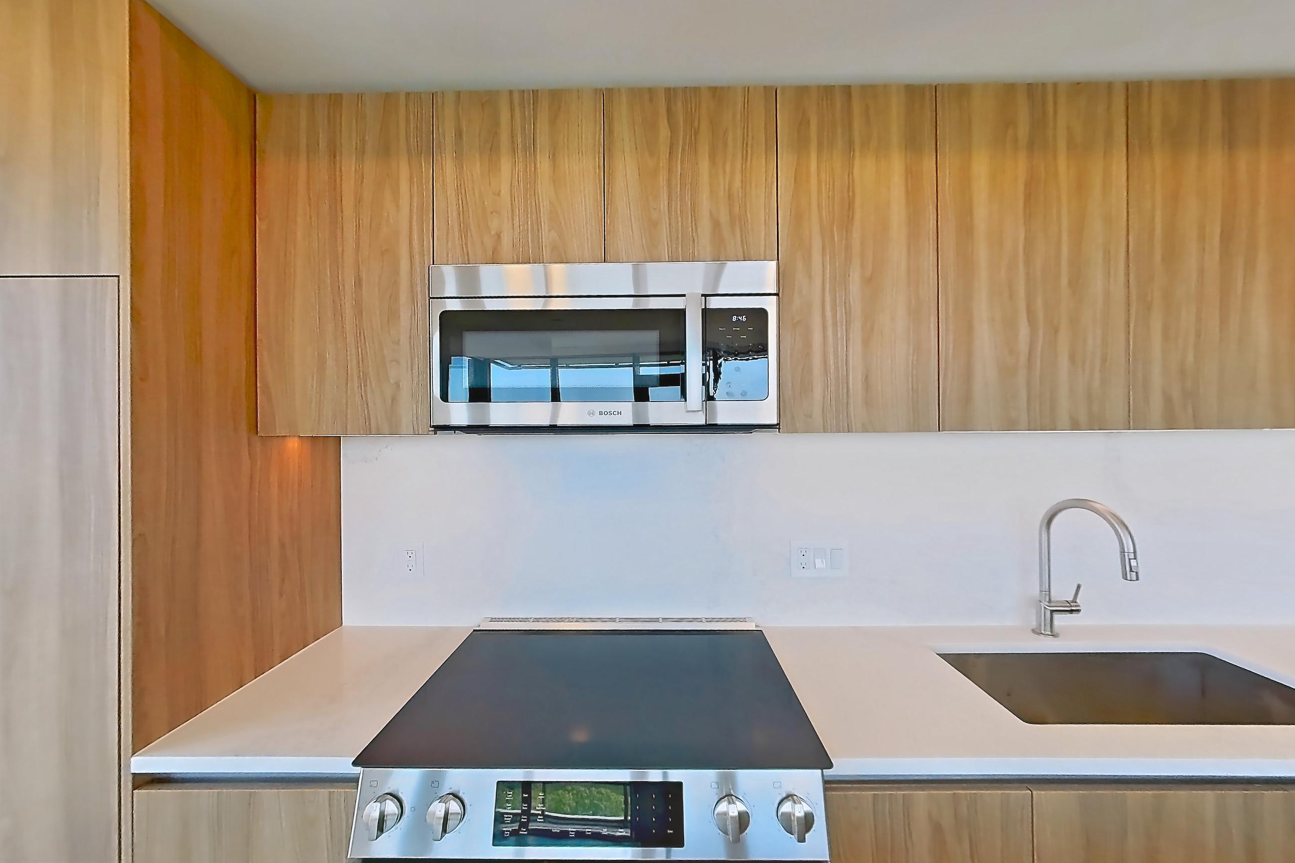 Kitchen with electric range, light stone countertops, light wood-finish flooring, oven/range, and stainless steel appliances, Apartment 1508 at Zephyr