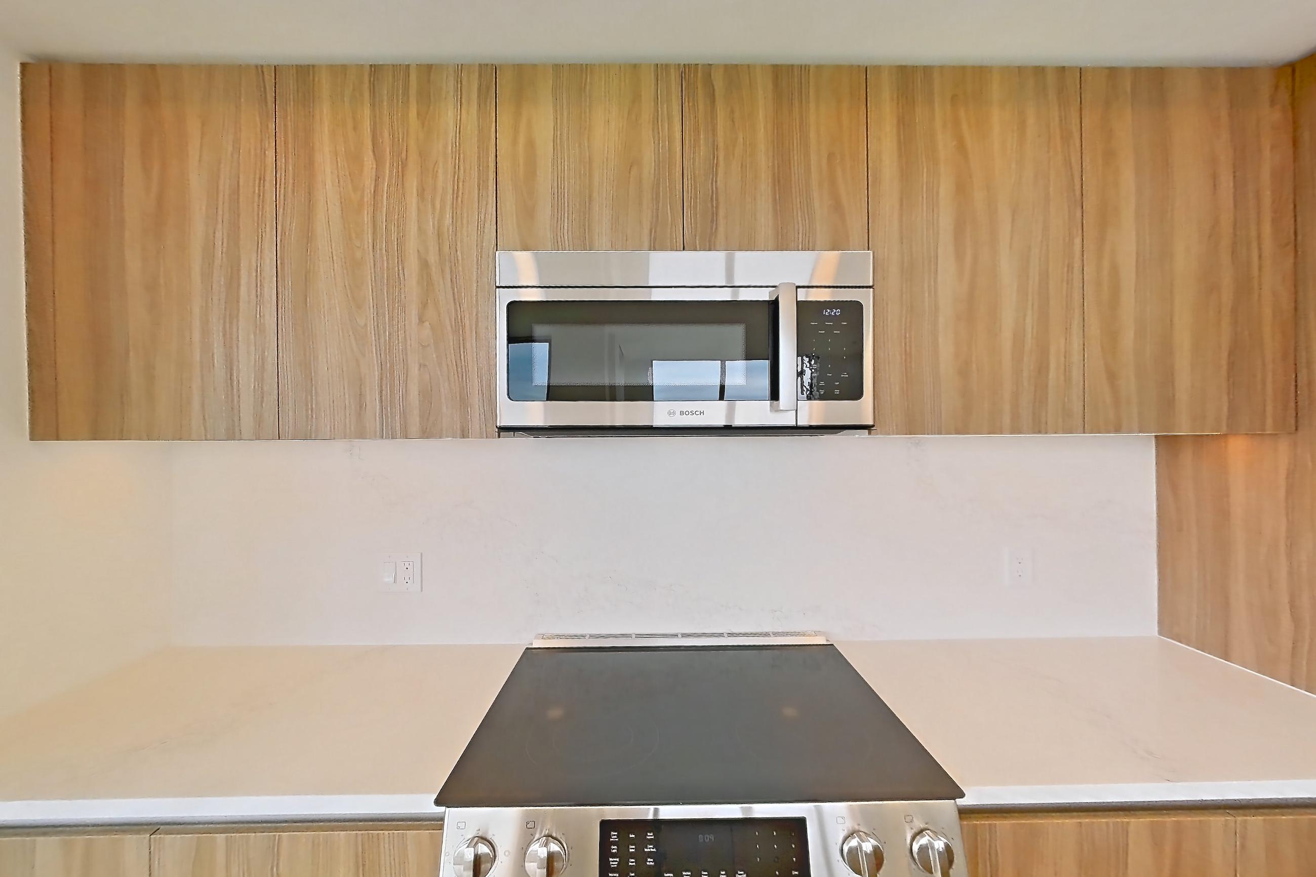 Kitchen with electric range, light stone countertops, light wood-finish flooring, oven/range, and stainless steel appliances, Apartment 1605 at Zephyr