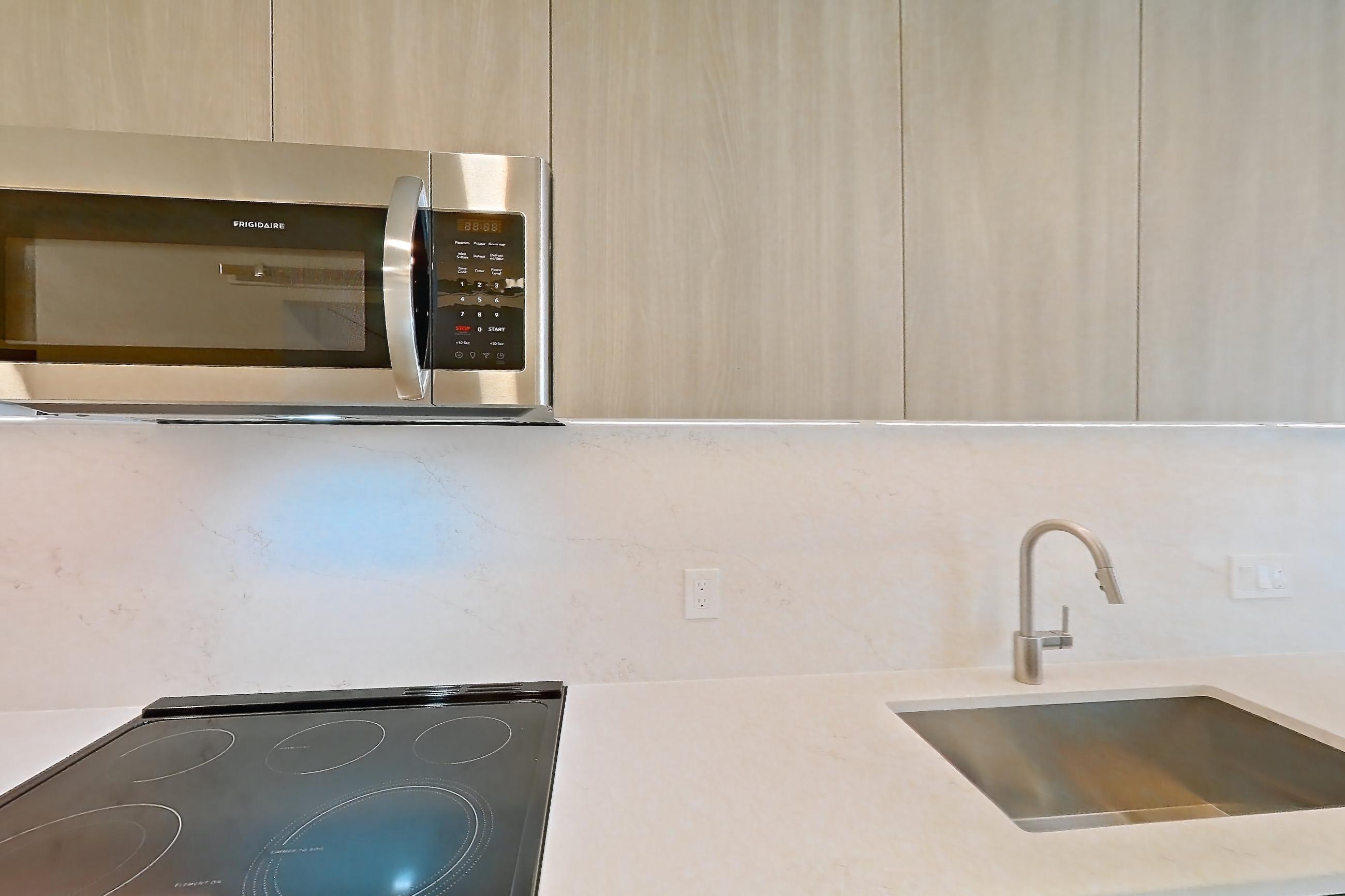 Kitchen with electric range, light stone countertops, light wood-finish flooring, oven/range, stainless steel appliances, and wood-finish flooring, Apartment 0822 at Zephyr