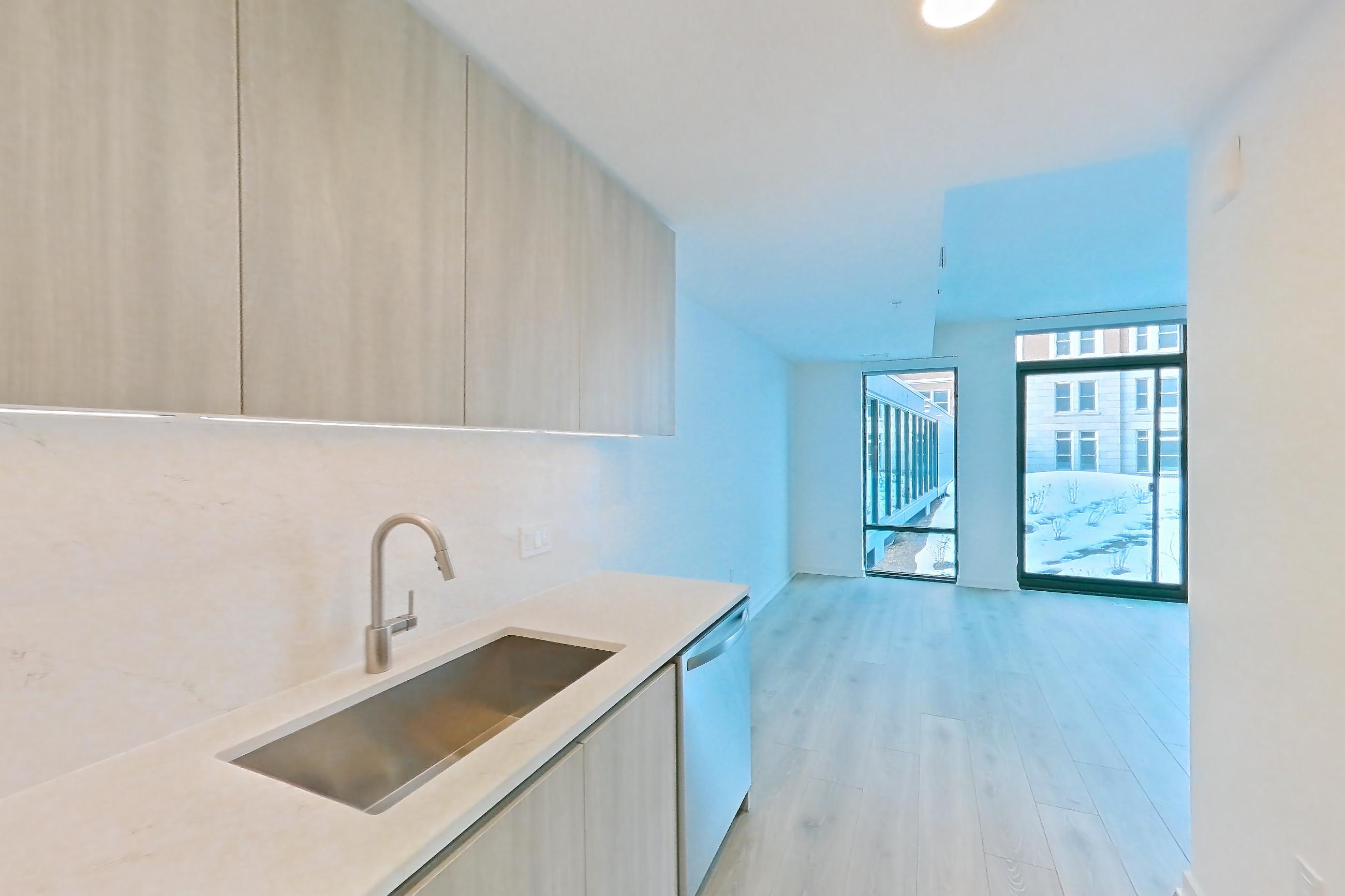 Kitchen with electric range, light stone countertops, light wood-finish flooring, oven/range, stainless steel appliances, and wood-finish flooring, Apartment 0822 at Zephyr