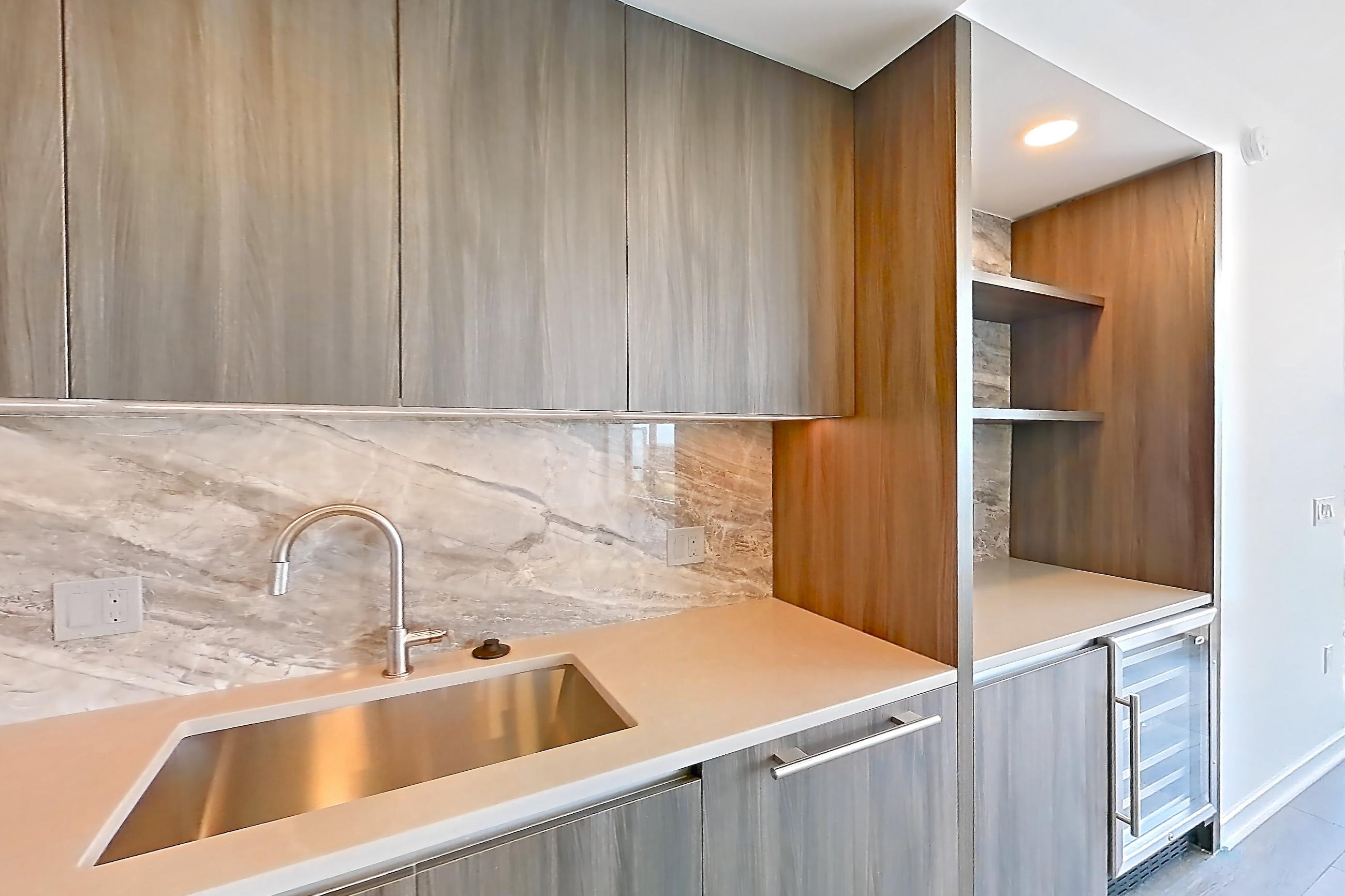 Kitchen with cooktop, gas cooktop, light stone countertops, light wood-finish flooring, oven/range, and stainless steel appliances, Apartment 1704 at Zephyr