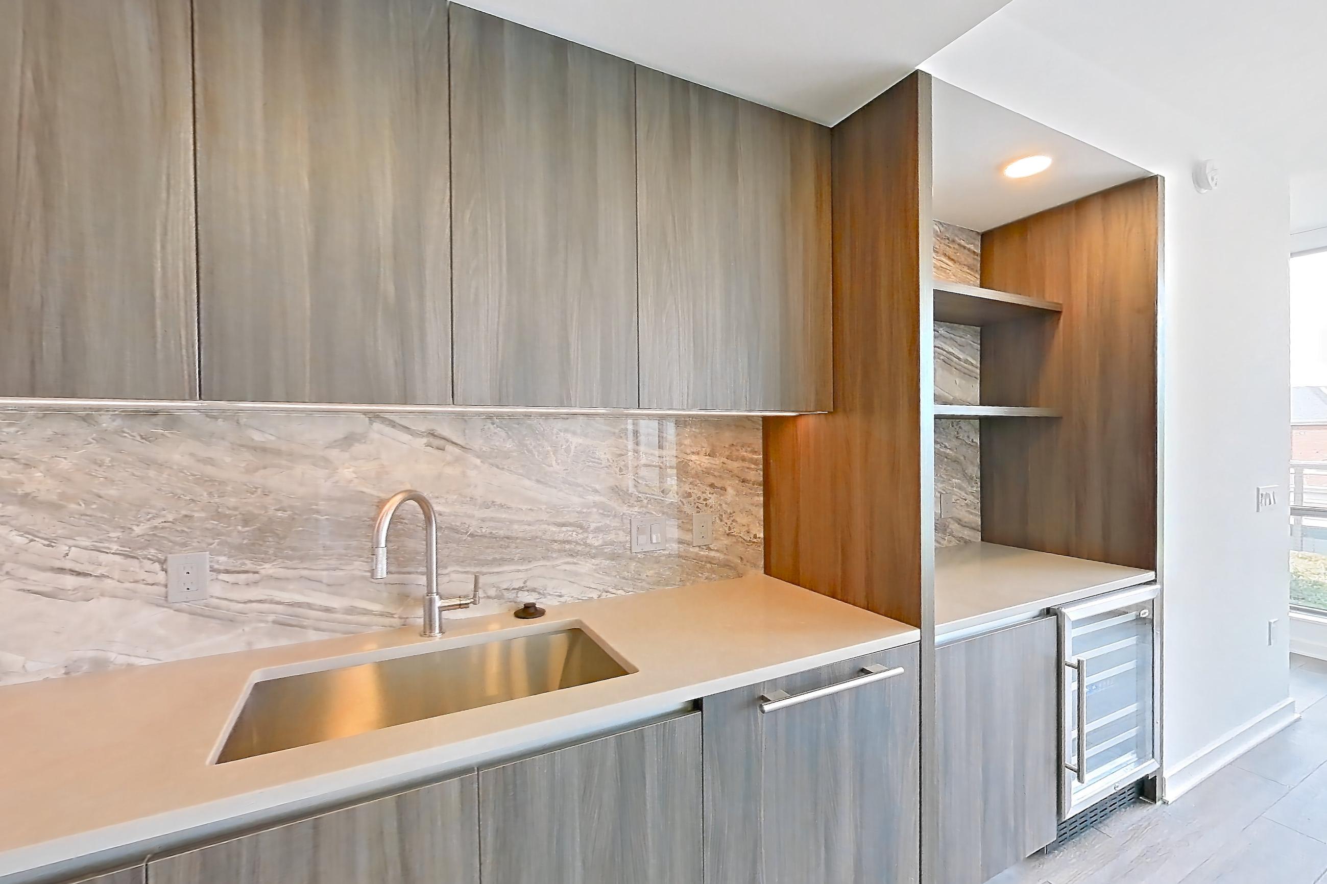 Kitchen with cooktop, gas cooktop, light stone countertops, light wood-finish flooring, oven/range, and stainless steel appliances, Apartment 1705 at Zephyr