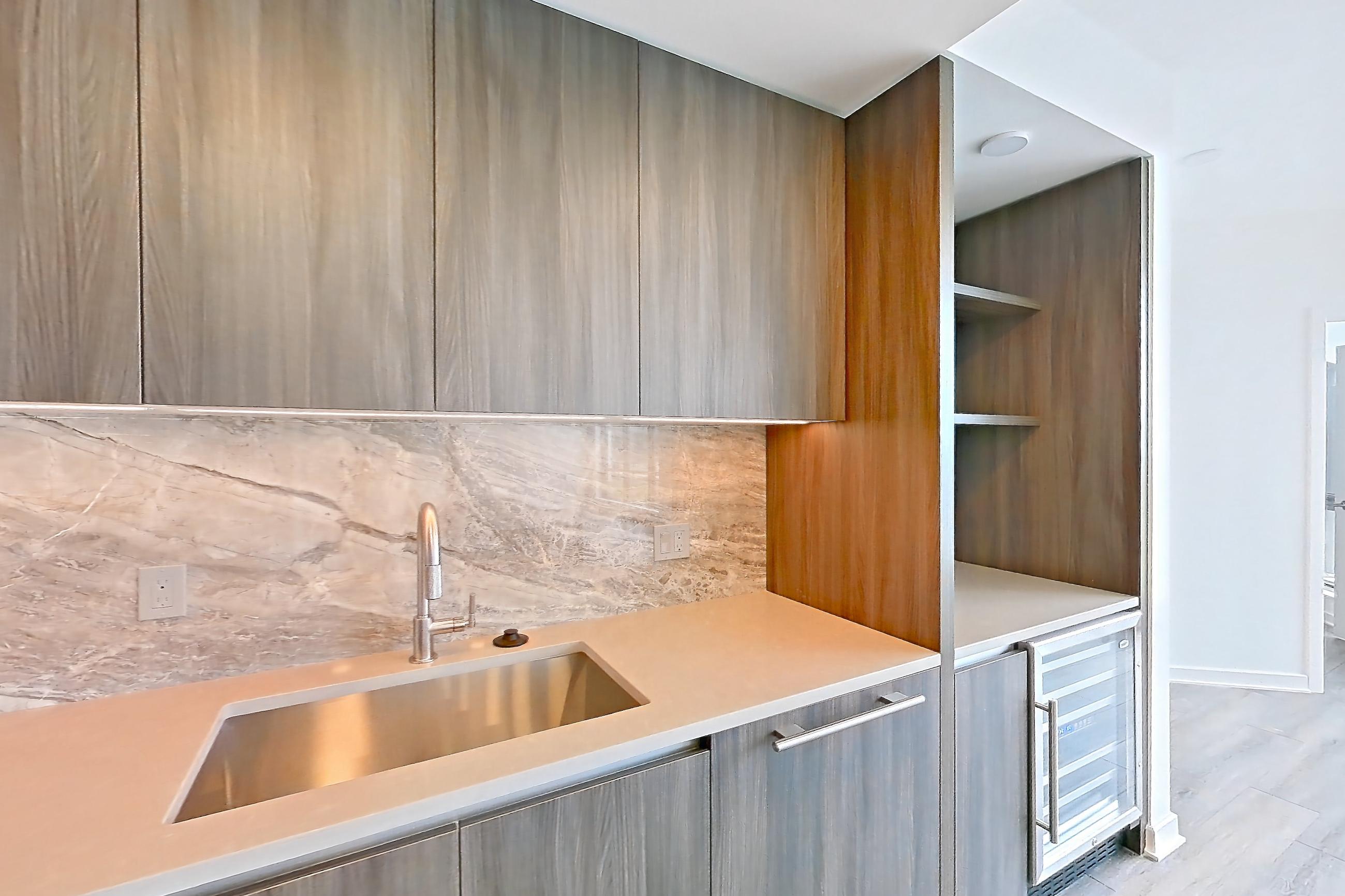 Kitchen with cooktop, gas cooktop, light stone countertops, light wood-finish flooring, oven/range, and stainless steel appliances, Apartment 1711 at Zephyr