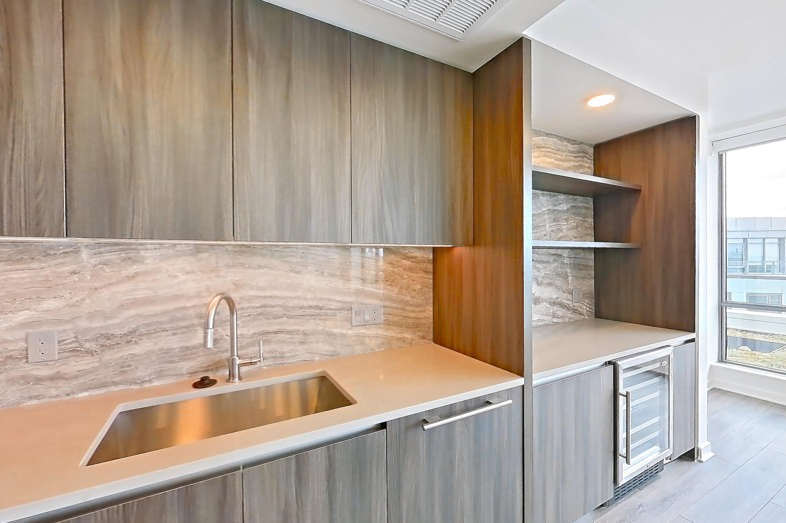 Kitchen with cooktop, gas cooktop, light stone countertops, light wood-finish flooring, oven/range, and stainless steel appliances, Apartment 1707 at Zephyr