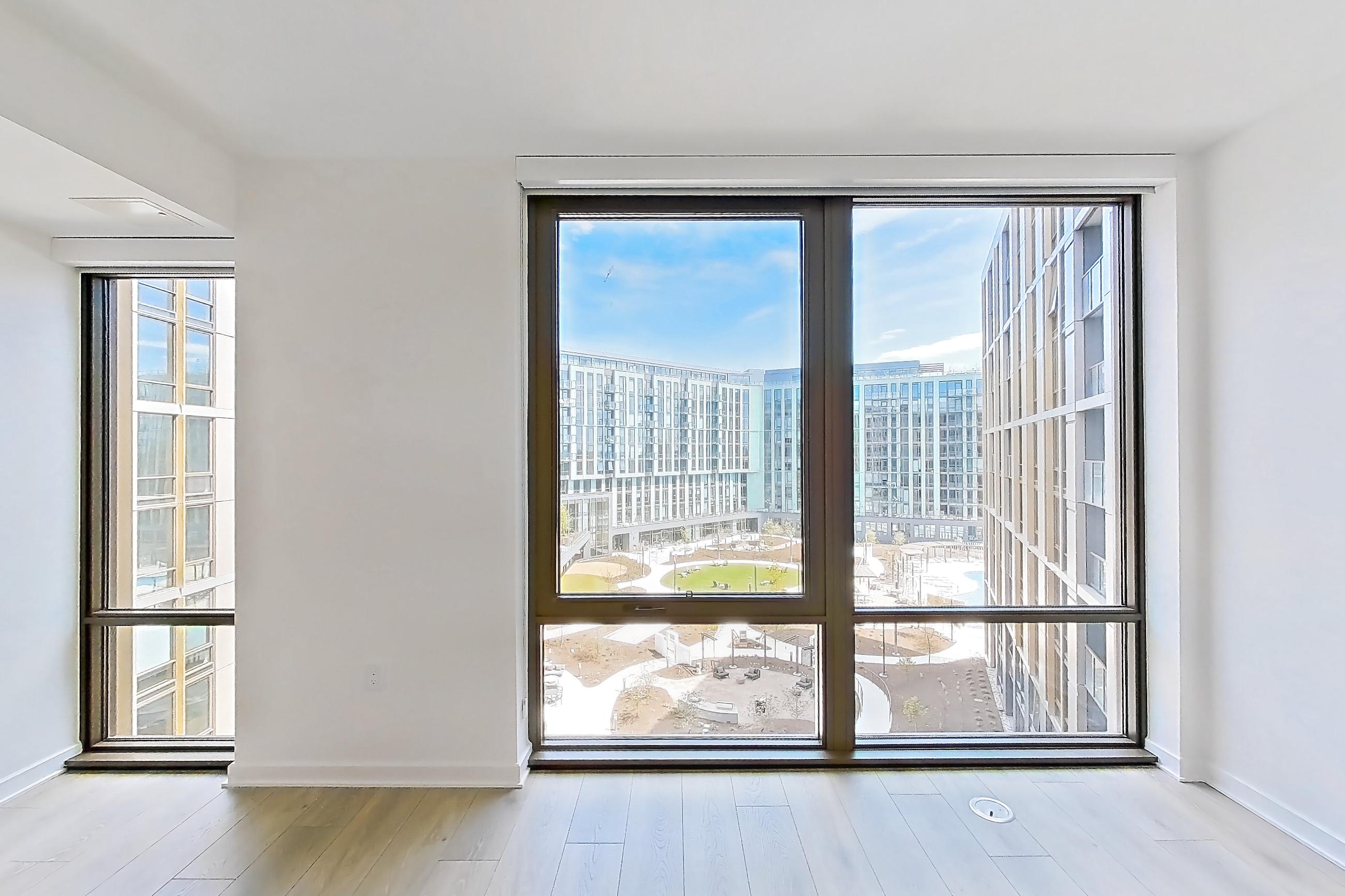 Living room with city view and light wood-finish flooring, Apartment 1243 at Zephyr
