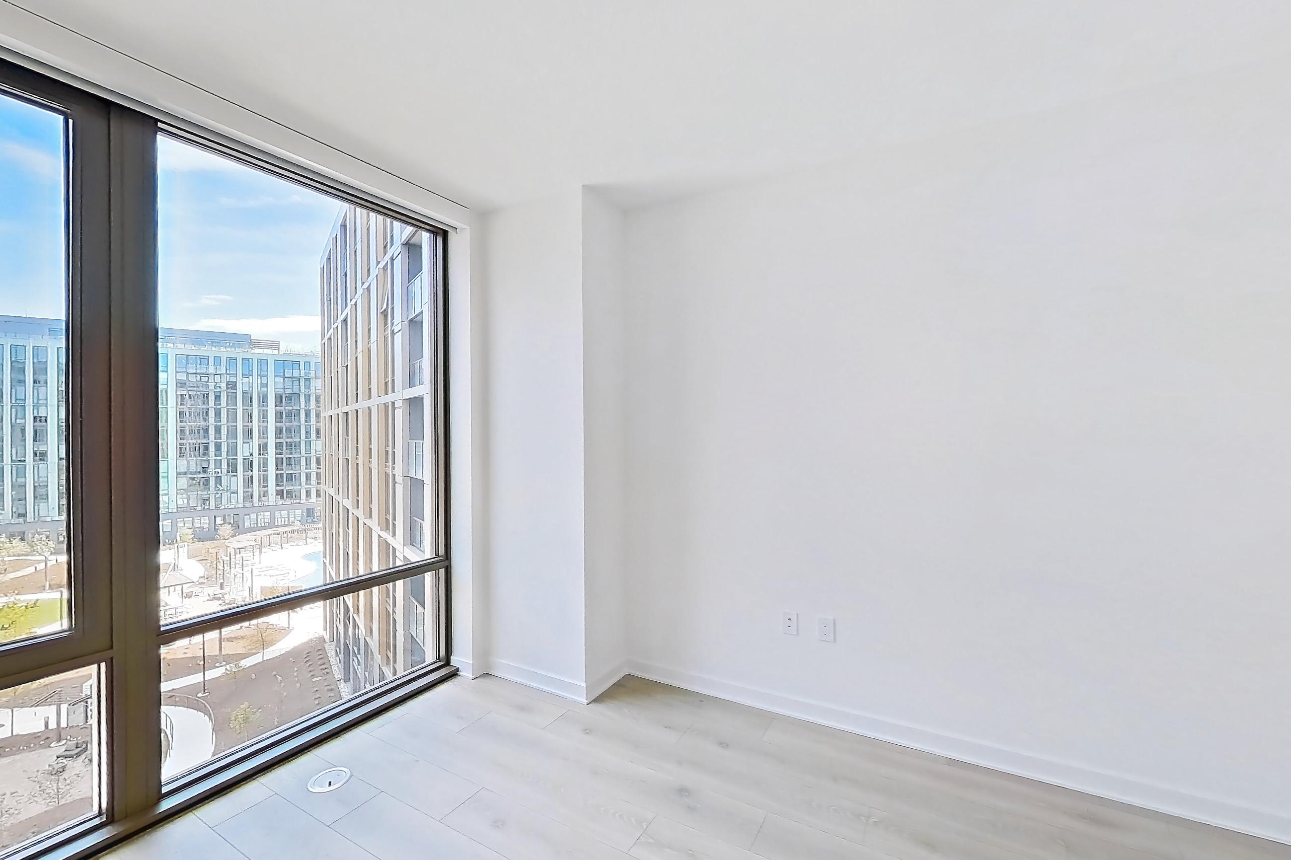 Living room with city view and light wood-finish flooring, Apartment 1243 at Zephyr